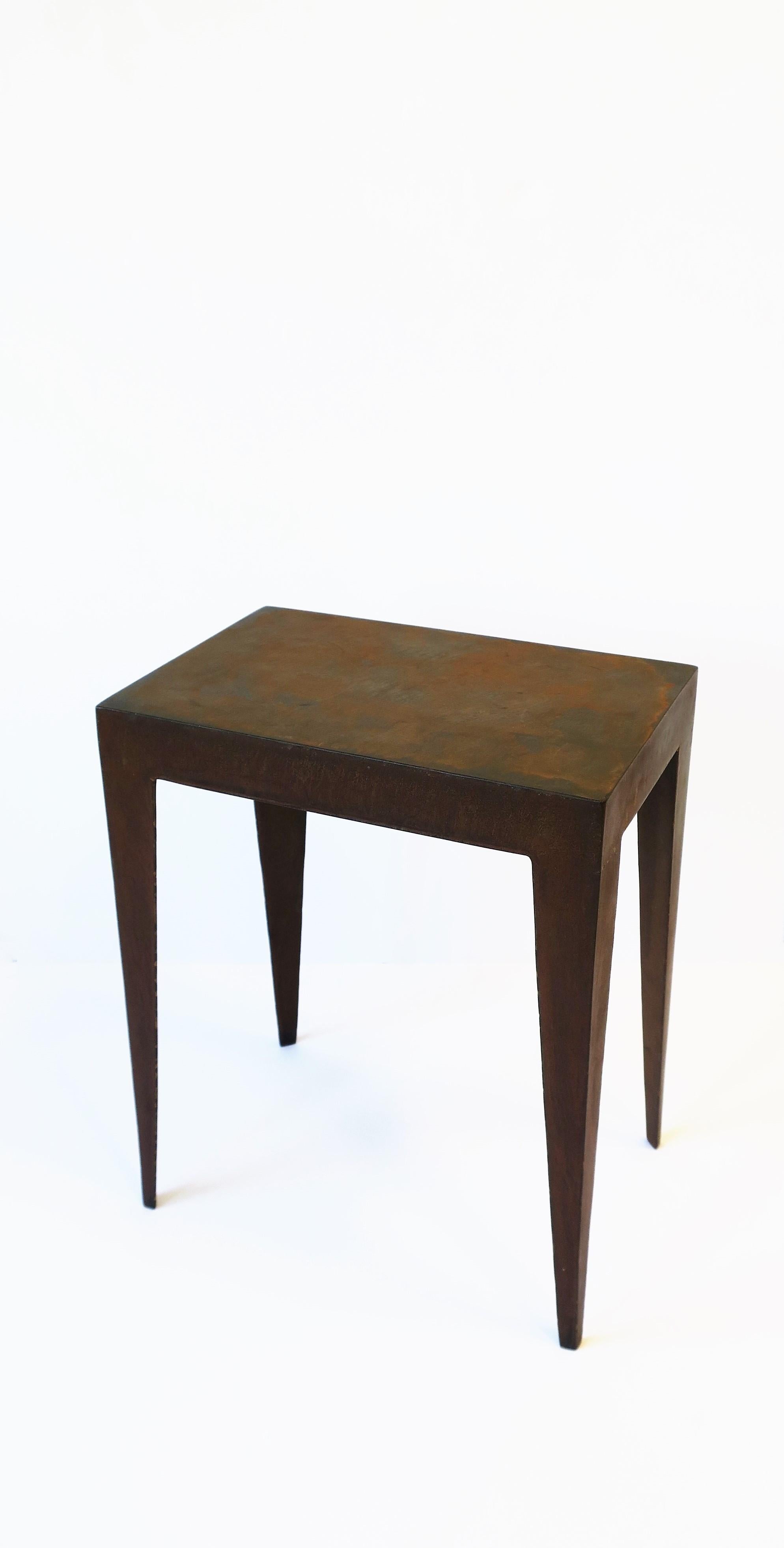 A substantial rectangular metal side, end, or drinks table with Art Deco influence, Minimalist style, circa late-20th century. Table is well-made with an intentional weathered surface and a Deco influence in the legs. Table is relatively small, a