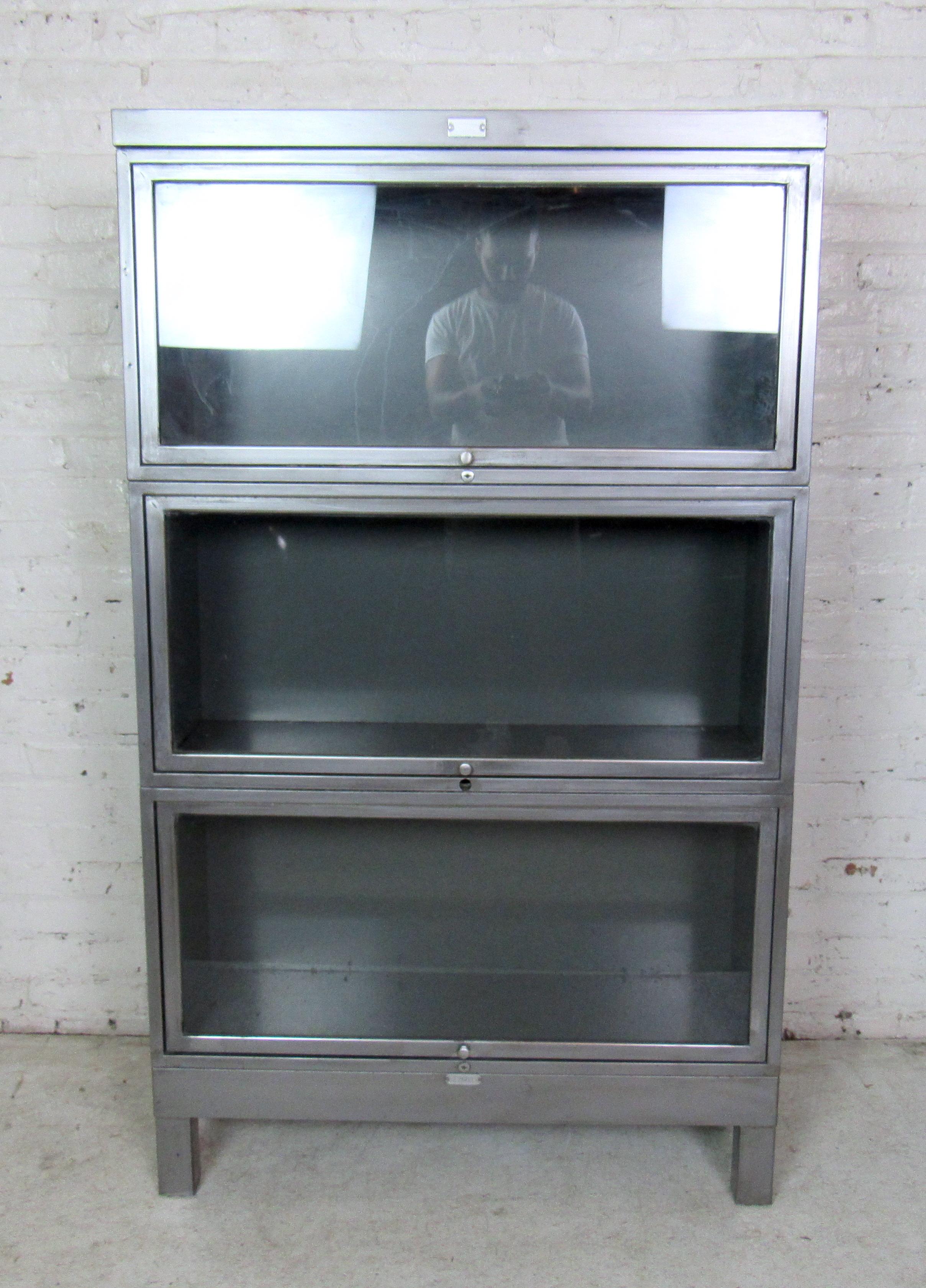 Vintage metal barrister bookcase, stacks three-high, glass window on each unit with polished brass handles, refinished with a bare metal style.

(Please confirm item location - NY or NJ - with dealer).