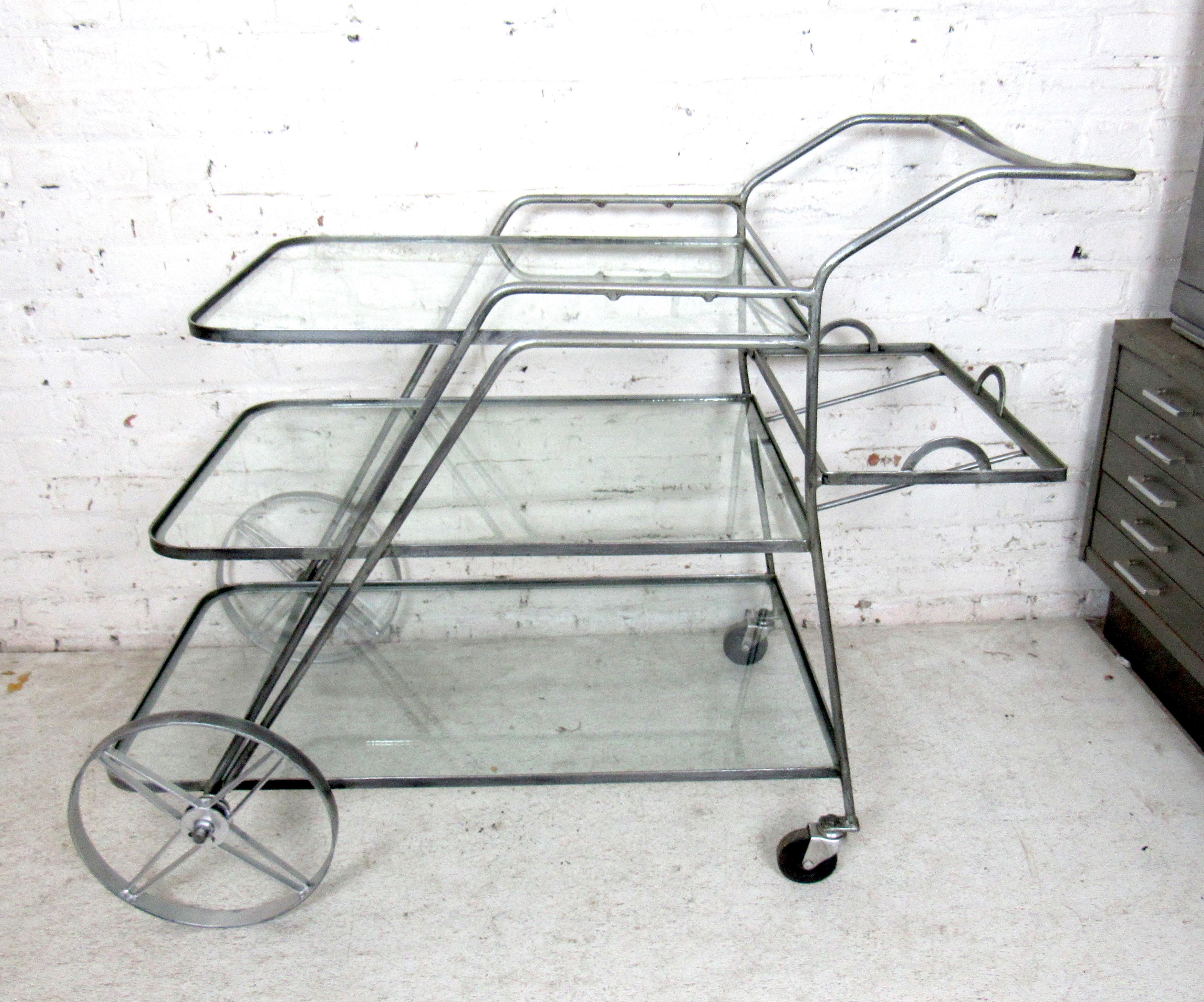 Vintage Industrial metal three-tier serving cart featuring glass shelving and large metal wheels.

Please confirm item location with dealer (NJ or NY).

   
