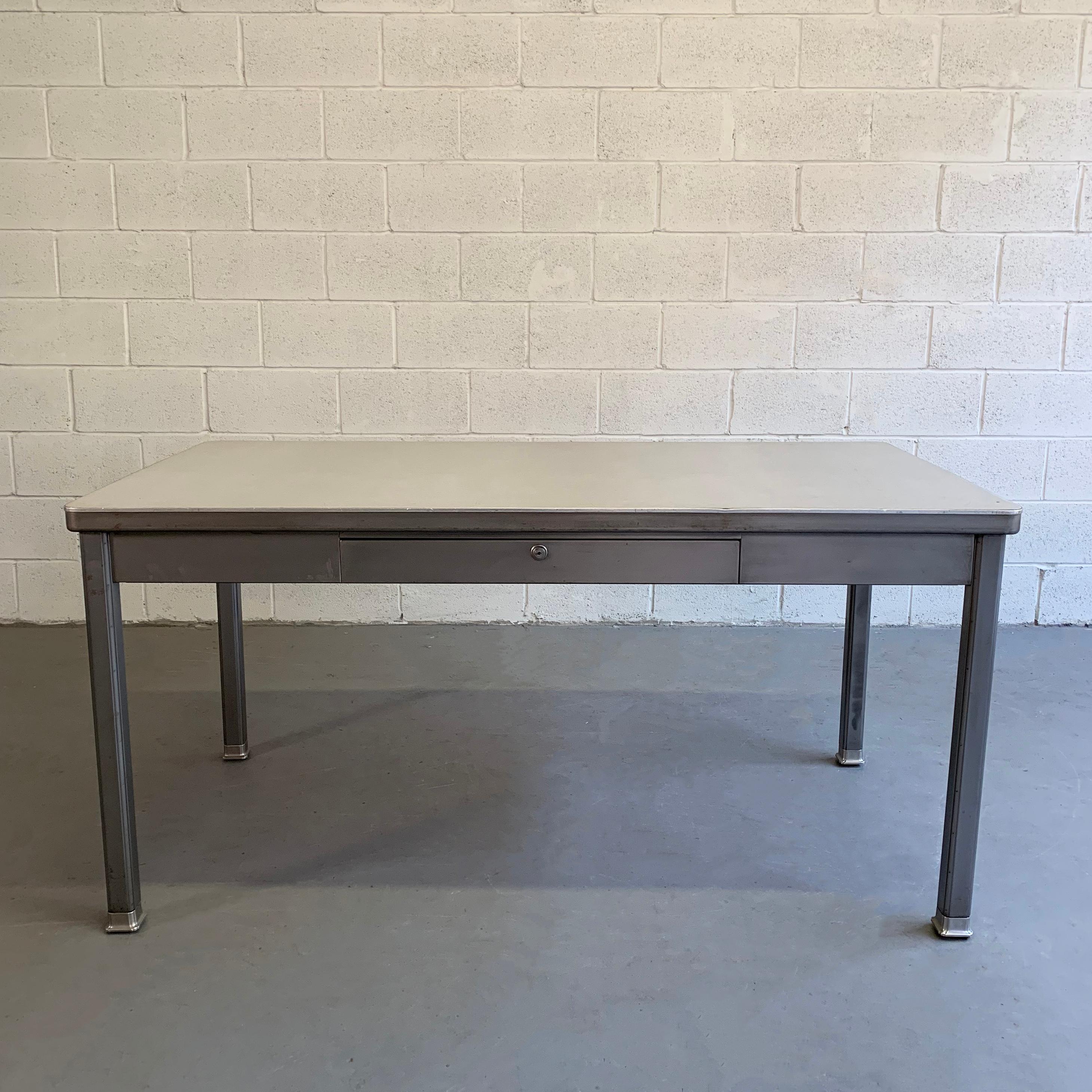 Industrial, midcentury, police station desk by General Fire Proofing Company features a brushed steel frame with Formica top. Height to the drawer is 25 inches.