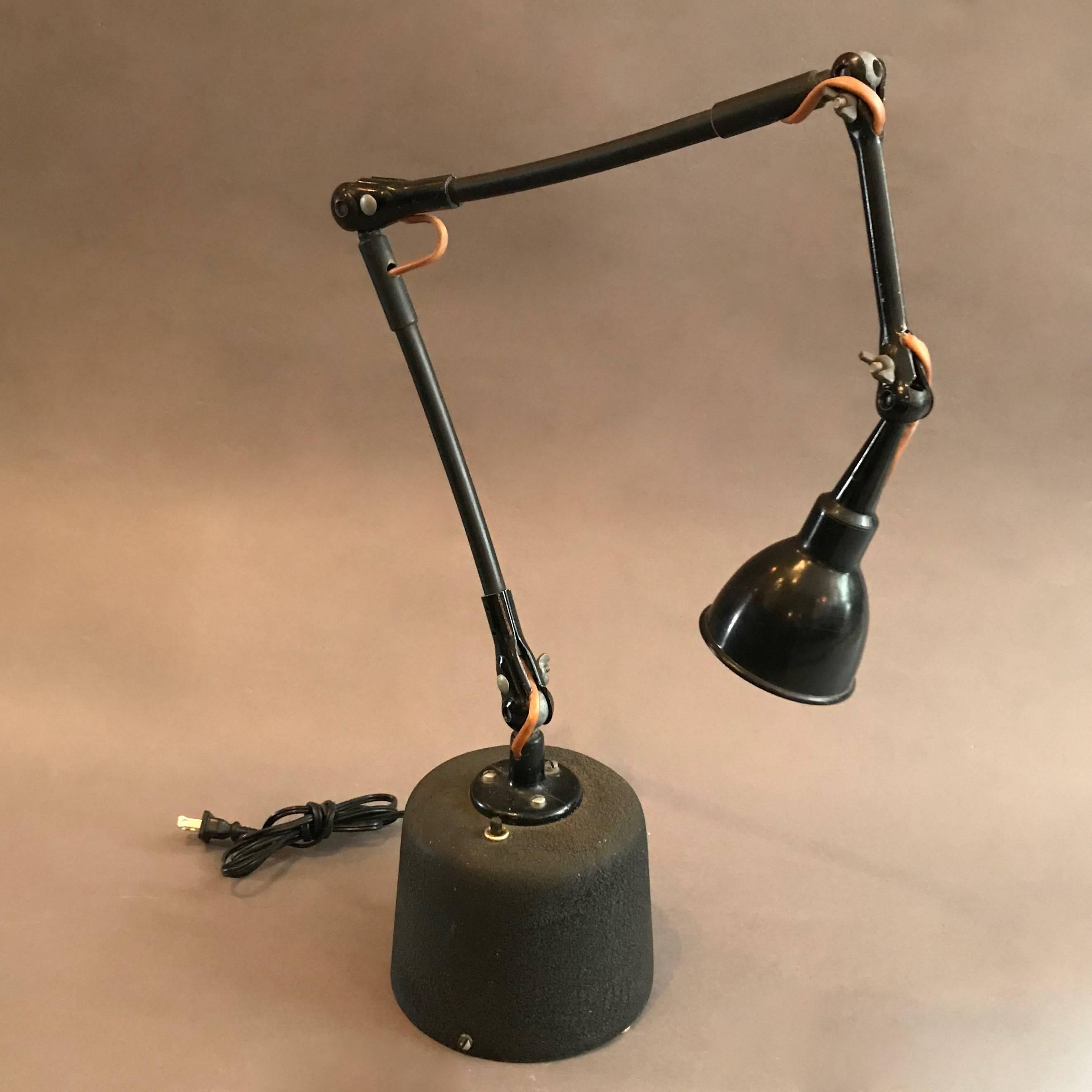 Industrial, tabletop, military airplane navigation, task lamp features a 6.25 inch diameter x 5.5 inch height cast metal, shrink paint base, that houses a low voltage transformer, and a 36 inch long arm that articulates at four joints. The lamp