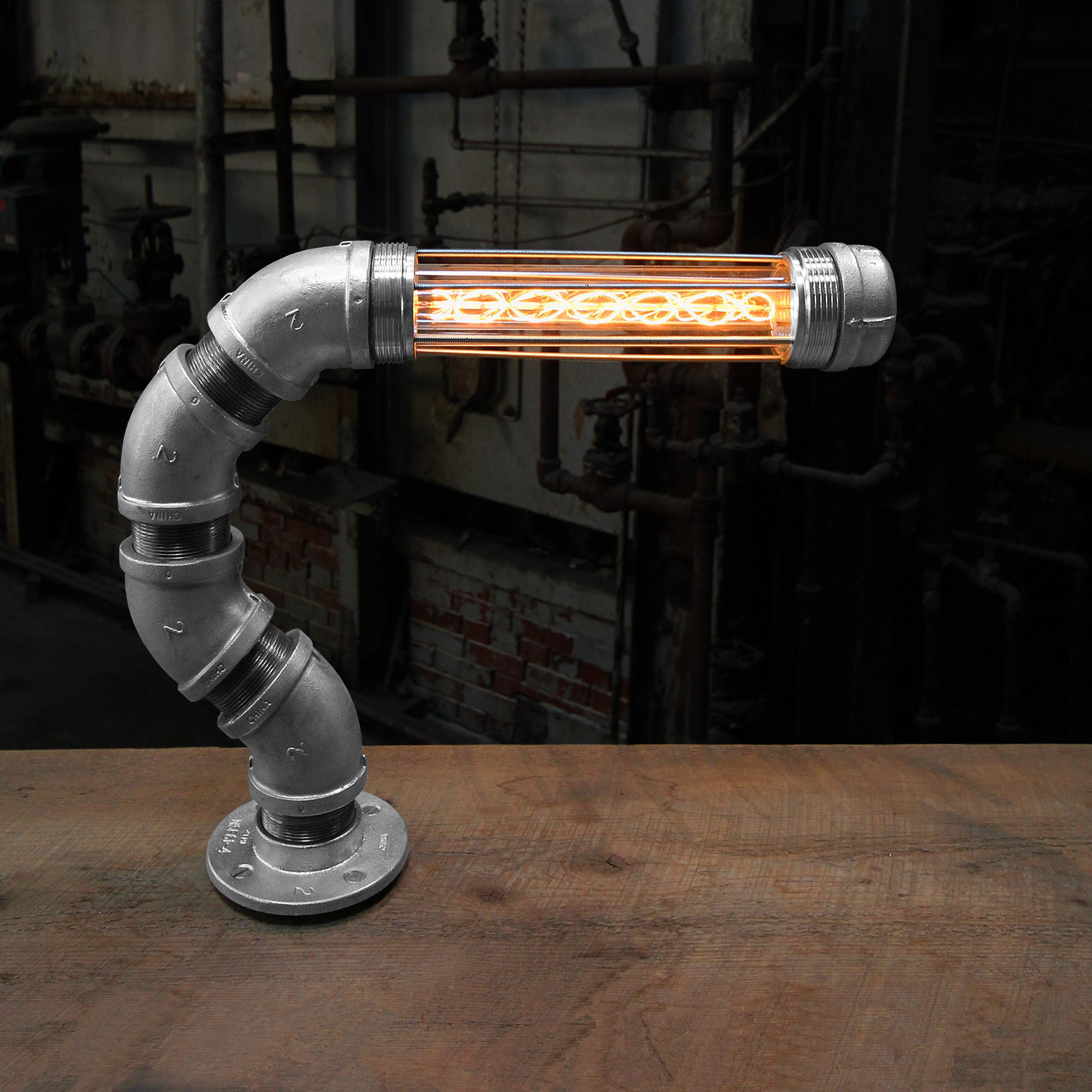 The Firefly modern industrial table lamp boasts a refined and organic shape with a perfectly balanced and cantilevered proprietary industrial light Module which creates a warm and moody glow to illuminate your favorite industrial style desk or side