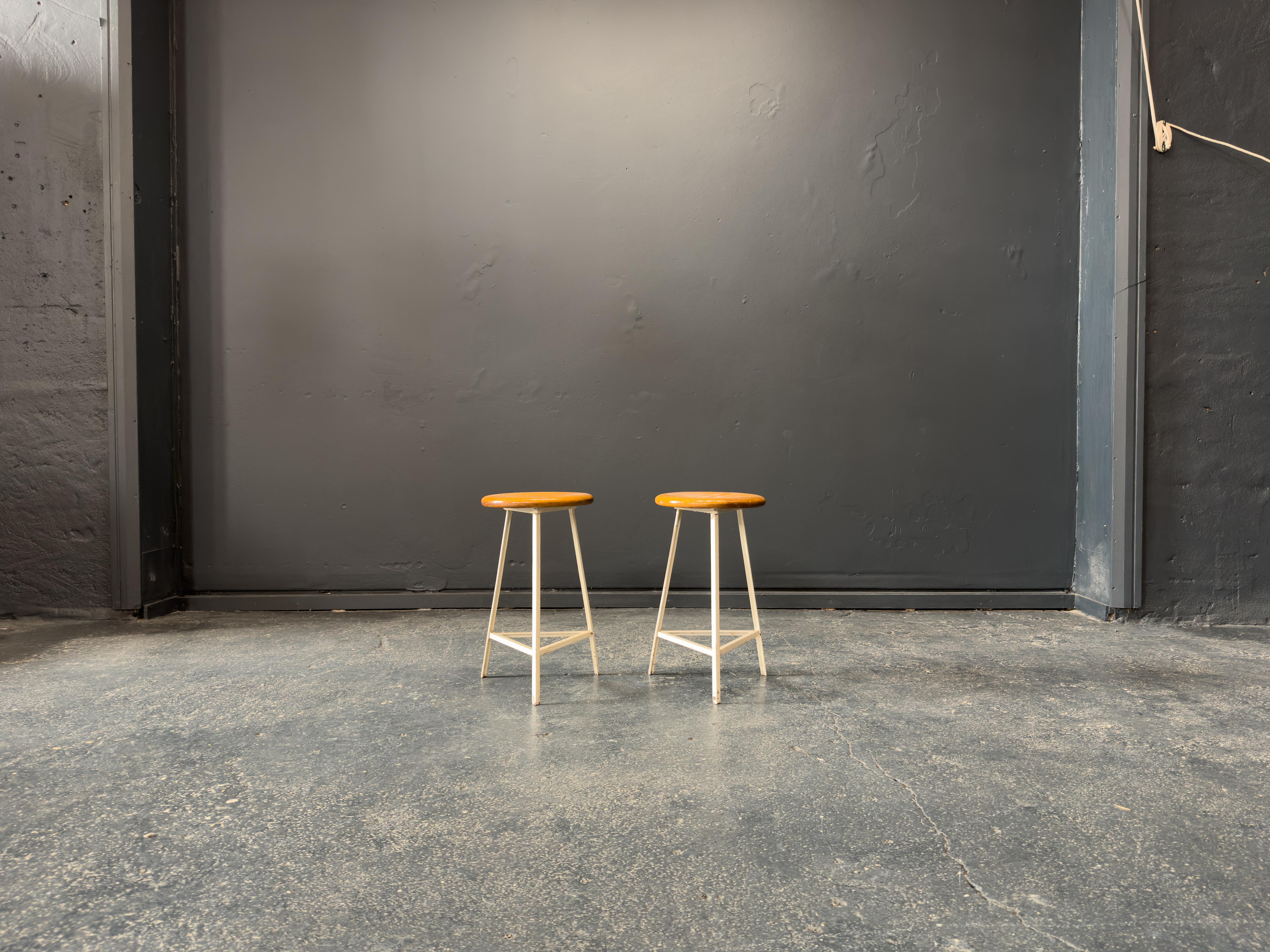 Questo sgabello in quercia e metallo fonde l'estetica moderna di metà secolo con il fascino utilitaristico, dando vita a un pezzo elegante e versatile. La seduta in rovere massiccio è liscia e circolare, con una delicata patina che mette in evidenza