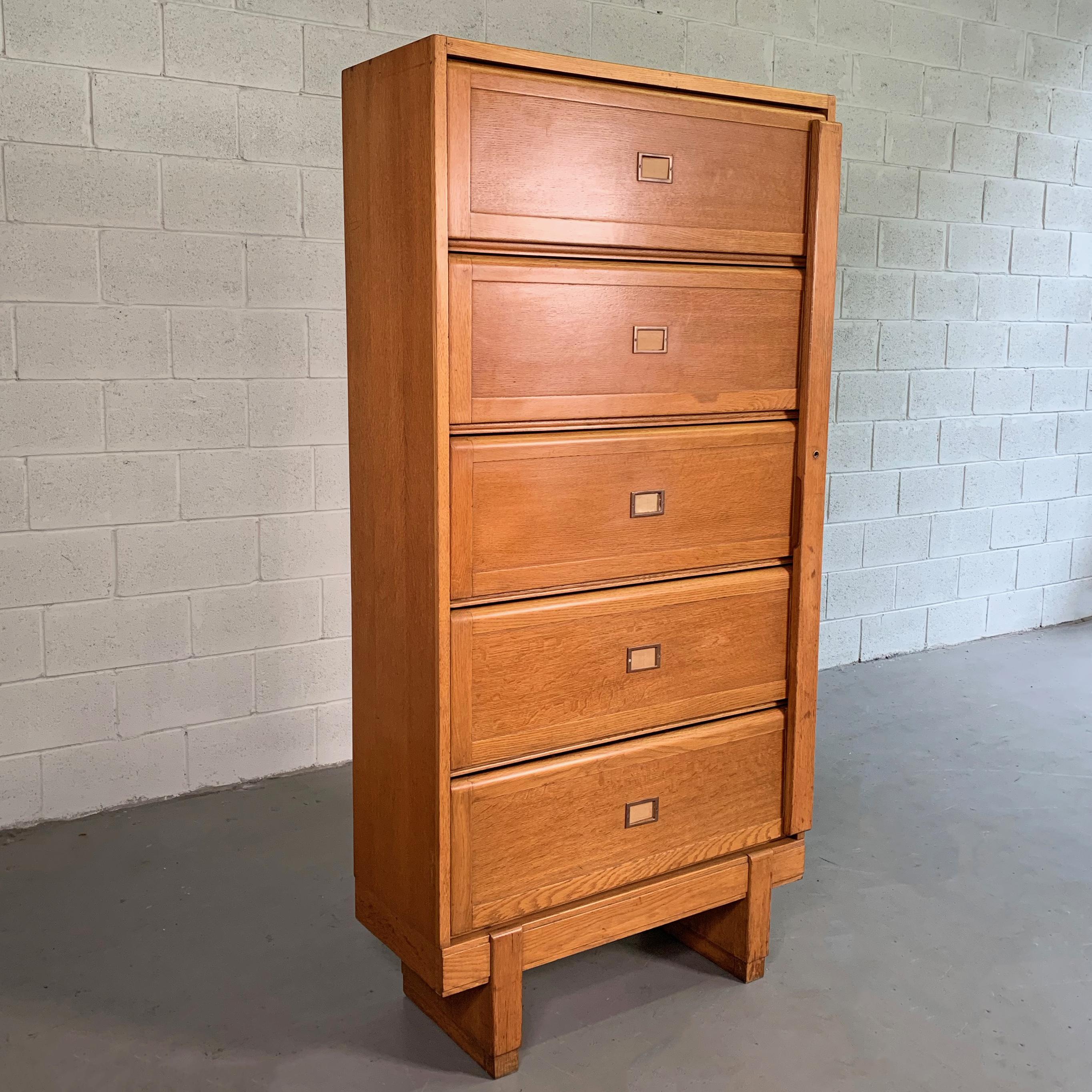 Wonderfully detailed, midcentury, industrial, solid oak, barrister bookcase, document cabinet features 5 divided cabinets with doors that slide up to open with side panel to lock the cabinets when all doors are closed with brass hardware. The drawer