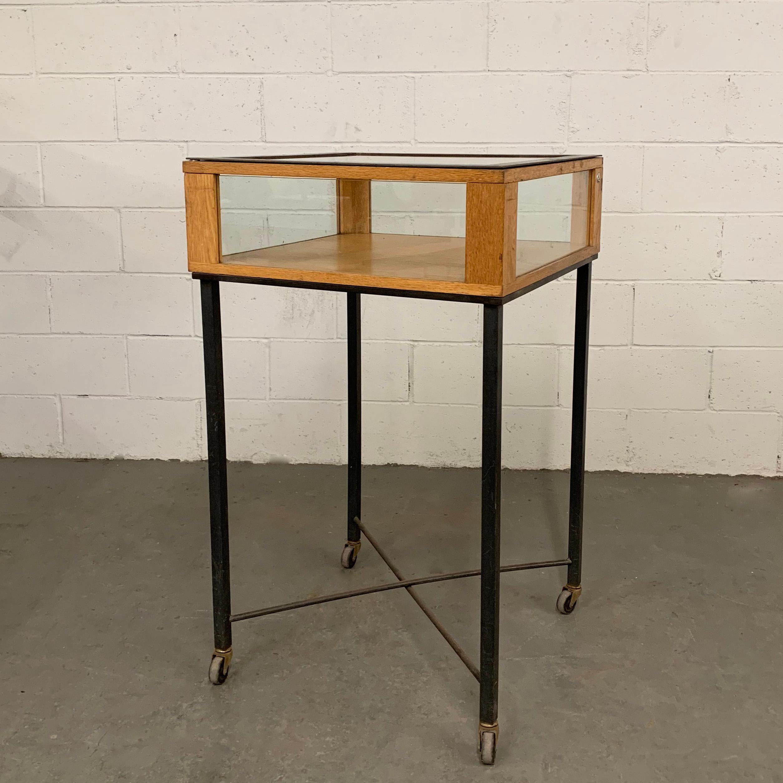 Industrial, jewelry display case features a 9 inch height, oak and glass display cabinet with steel frame on a rolling iron base. The case opens from the top.
