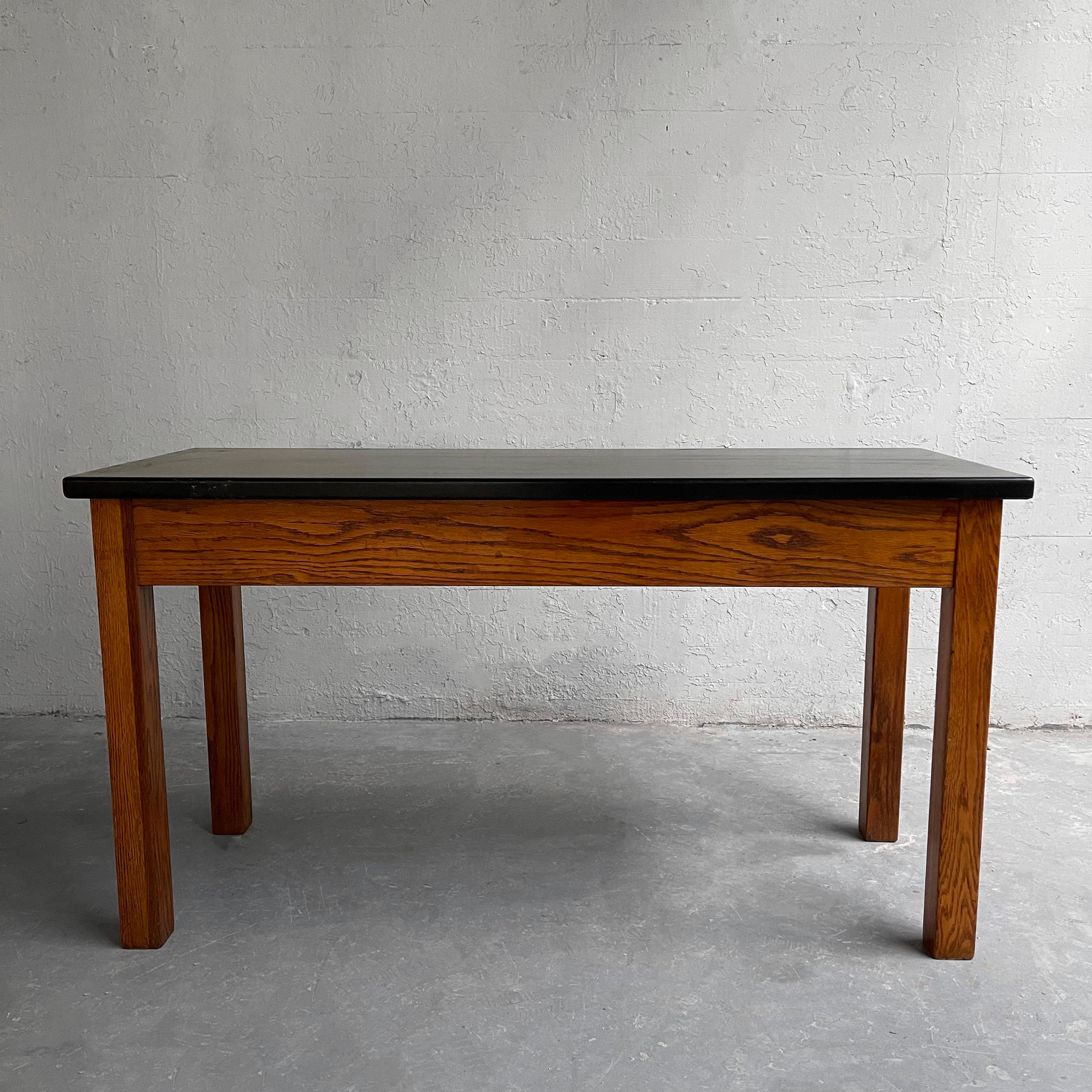 Consola de laboratorio industrial de mediados de siglo con base de roble y tablero de composite negro resistente a los ácidos para experimentos. Esta pieza es una gran consola, un esbelto escritorio o una mesa multimedia.