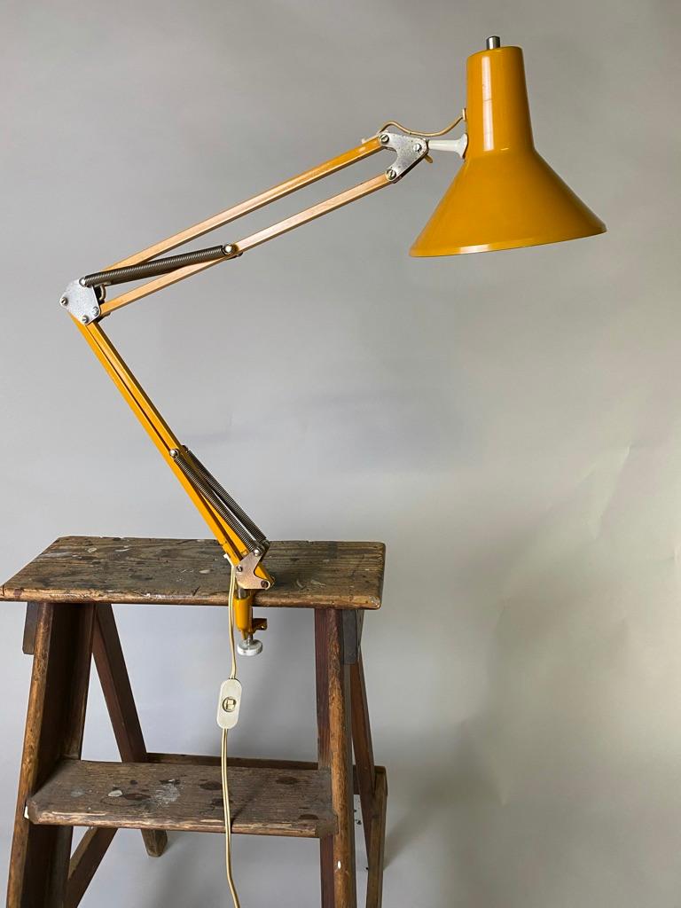 This working/ architects lamp from the 1970s is in full working order. It can be attached on a desk/table or shelf as well to a wall. The lamp has a beautiful patina (nicks and dents). The hasn't been rewired.
Measures: Total length 95 cm, height