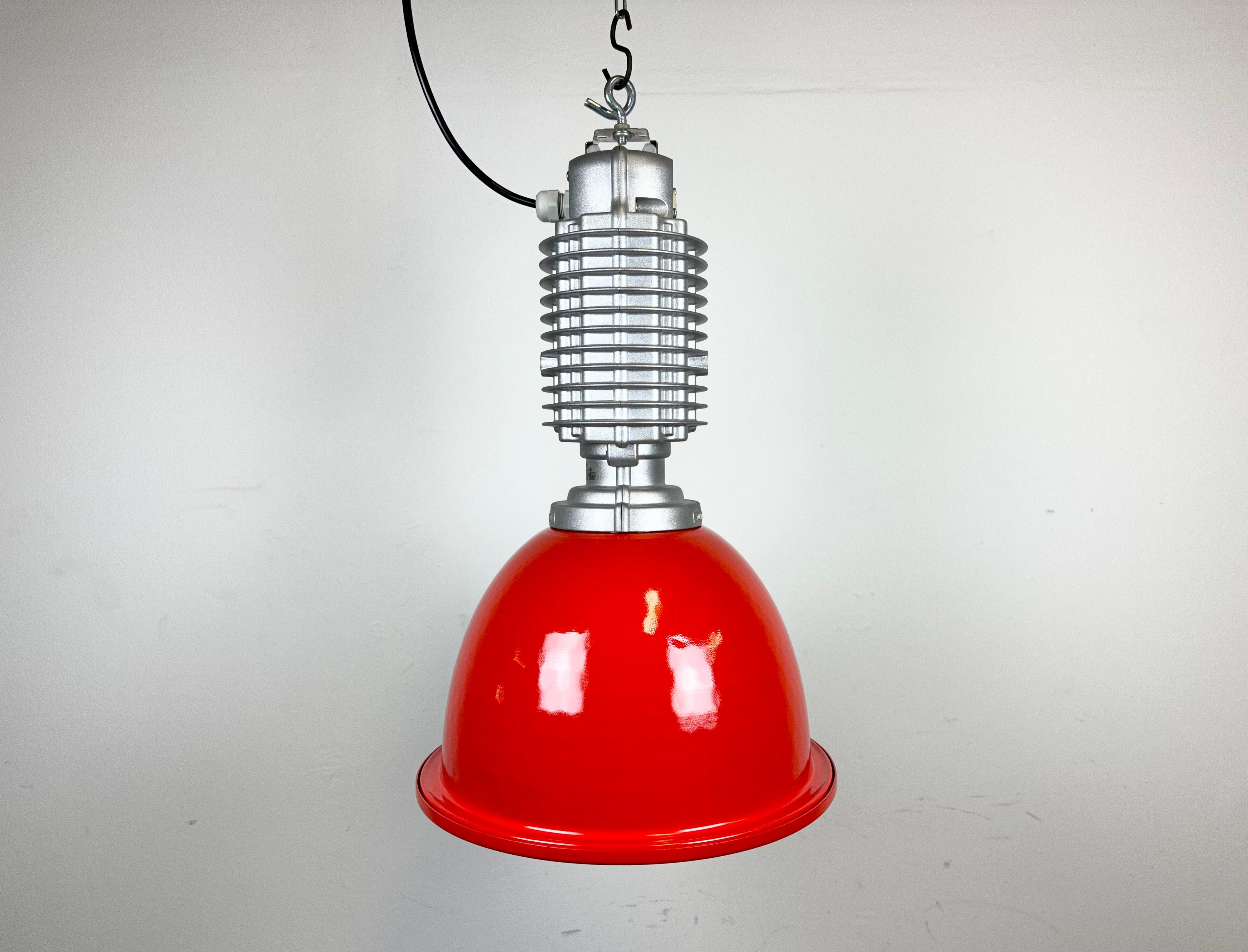 This industrial pendant lamp was designed by Charles Keller for Zumtobel Staff during the 1990s. It features a cast aluminum top and an aluminium shade, newly painted on red. New porcelain socket requires E27/ E26 light bulbs. New wire The diameter