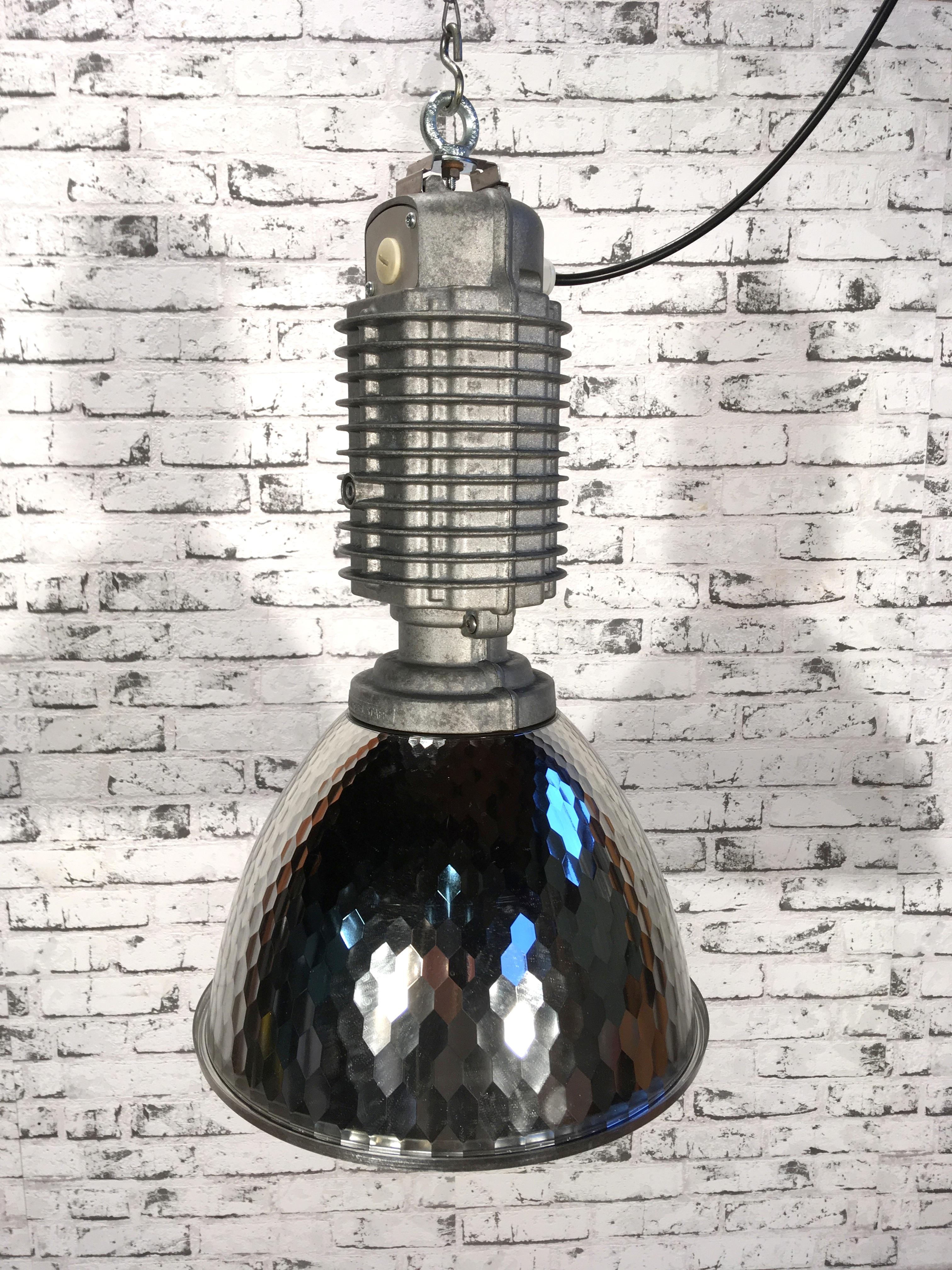 This industrial pendant was designed by Charles Keller for Zumtobel and was used in factories. It features cast aluminium top, silver plastic shade, new porcelain socket for E 27 bulbs and new wire. This vintage item has no defects, but it may show