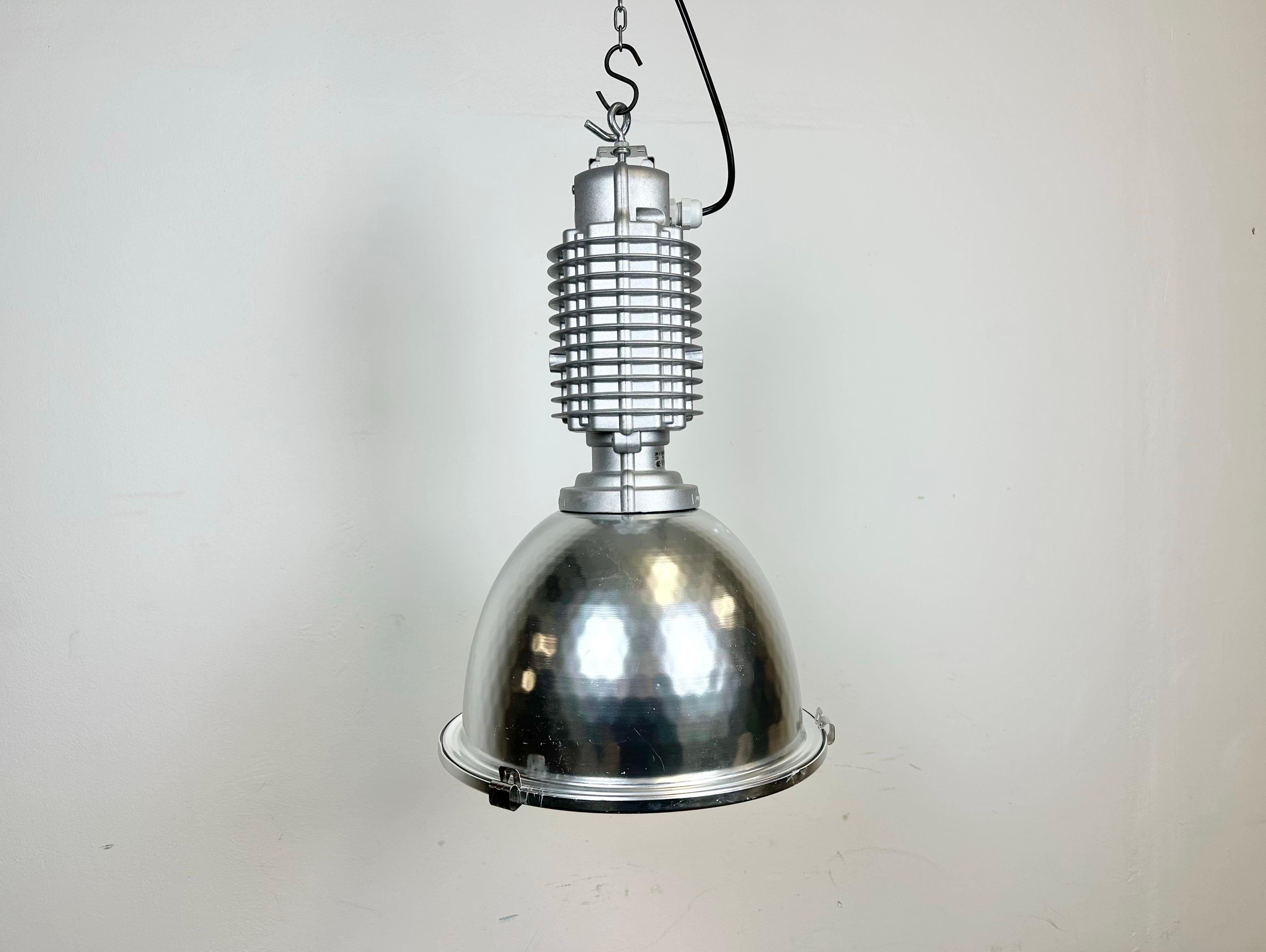 This industrial pendant lamp was designed by Charles Keller for Zumtobel Staff during the 1990s. It features a cast aluminum top and an aluminium shade with glass cover. New porcelain socket requires E27/ E26 lightbulbs. New wire. The diameter of