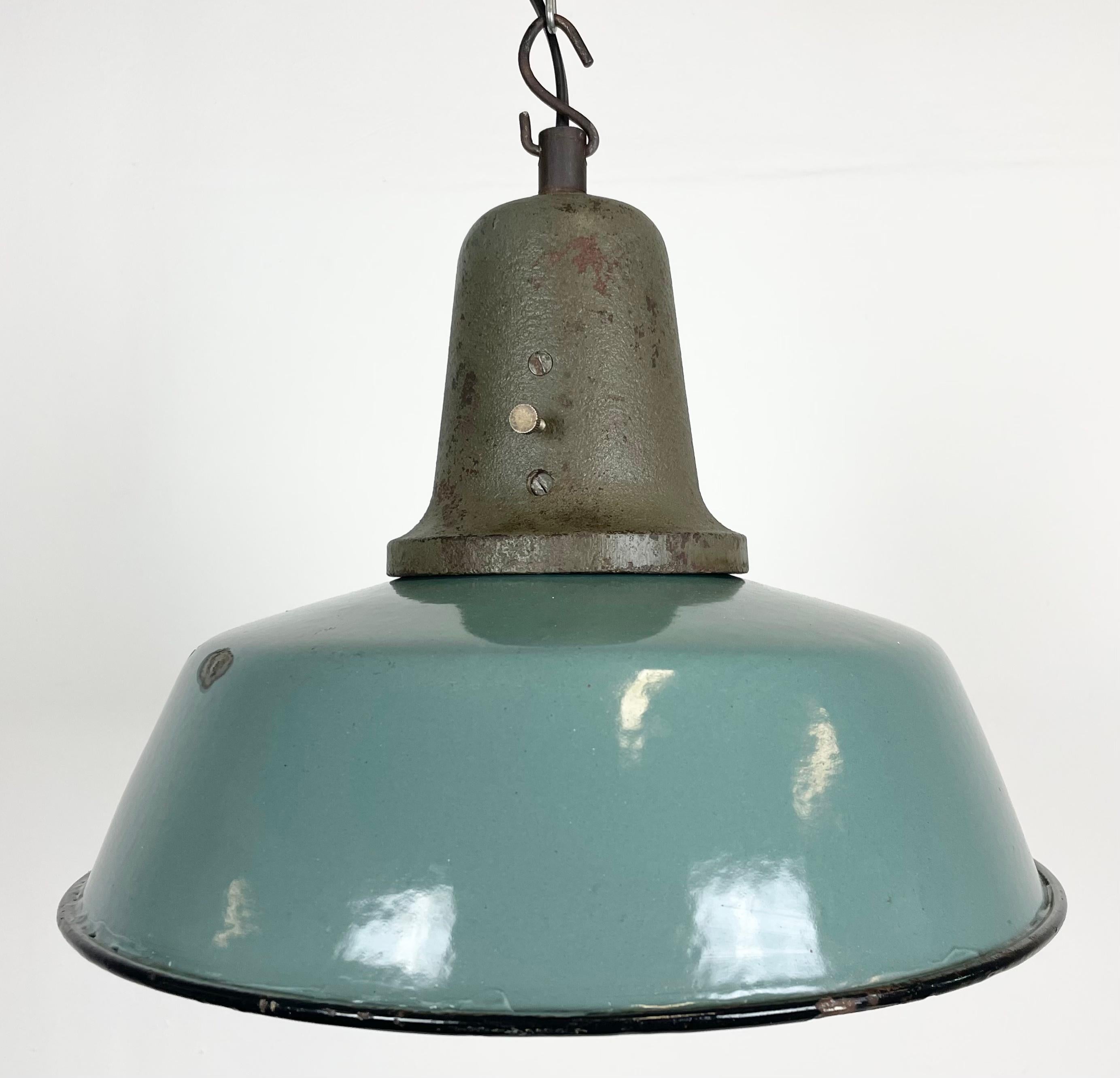 Industrial petrol enamel pendant light made in Poland during the 1960s. White enamel inside the shade. Cast iron top. The porcelain socket requires E 27/ E26 light bulbs. New wire. Fully functional. The weight of the lamp is 2,8 kg.