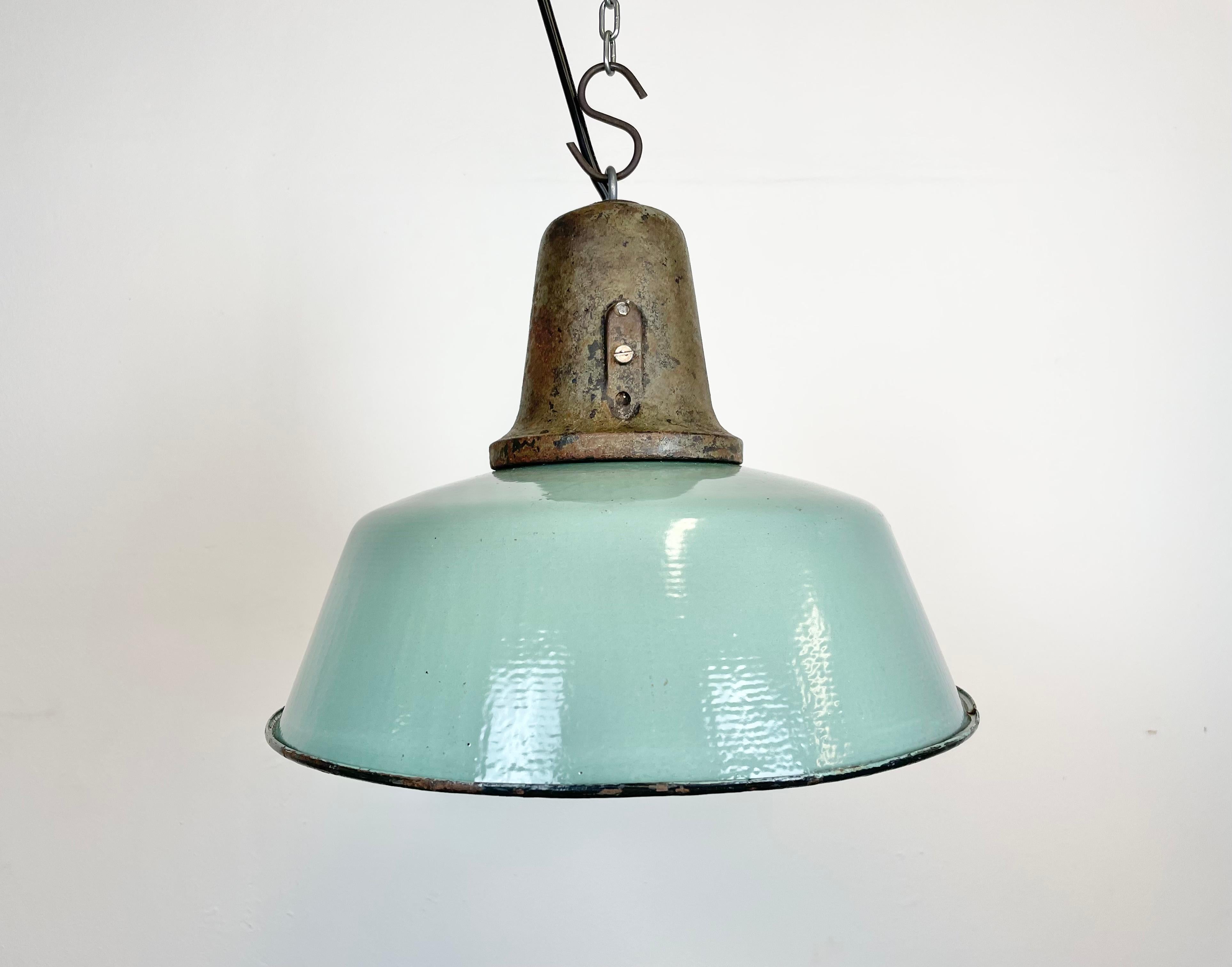 Industrial petrol enamel pendant light made in Poland during the 1960s. White enamel inside the shade. Cast iron top. The porcelain socket requires E 27/ E26 light bulbs. New wire. Fully functional. The weight of the lamp is 2,5 kg.