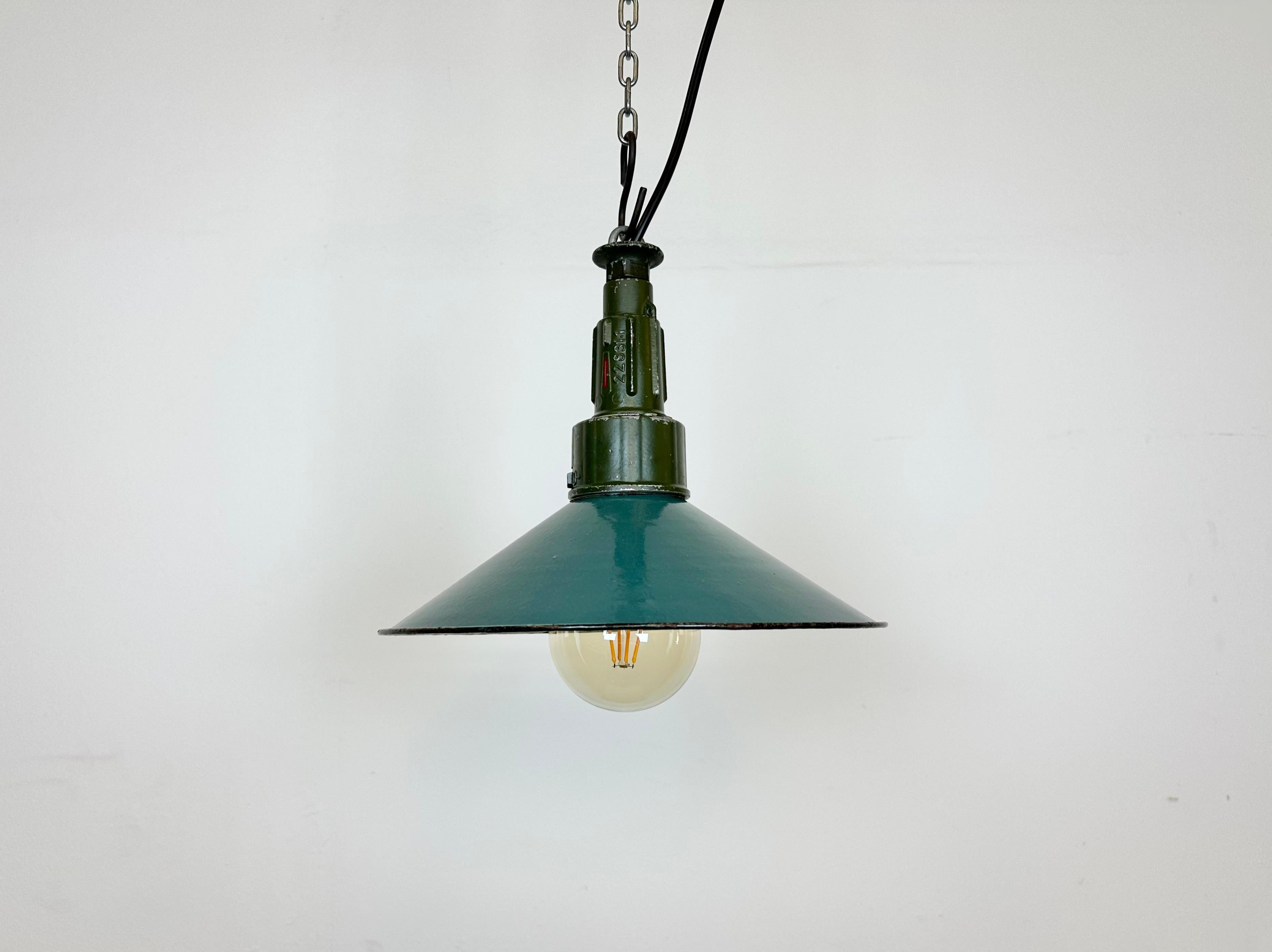Industrial petrol enamel pendant light made in Poland during the 1960s. White enamel inside the shade. Green cast aluminium top. The socket requires standard E 27/ E26 light bulbs. New wire. The diameter of the shade is 26cm. The weight of the lamp
