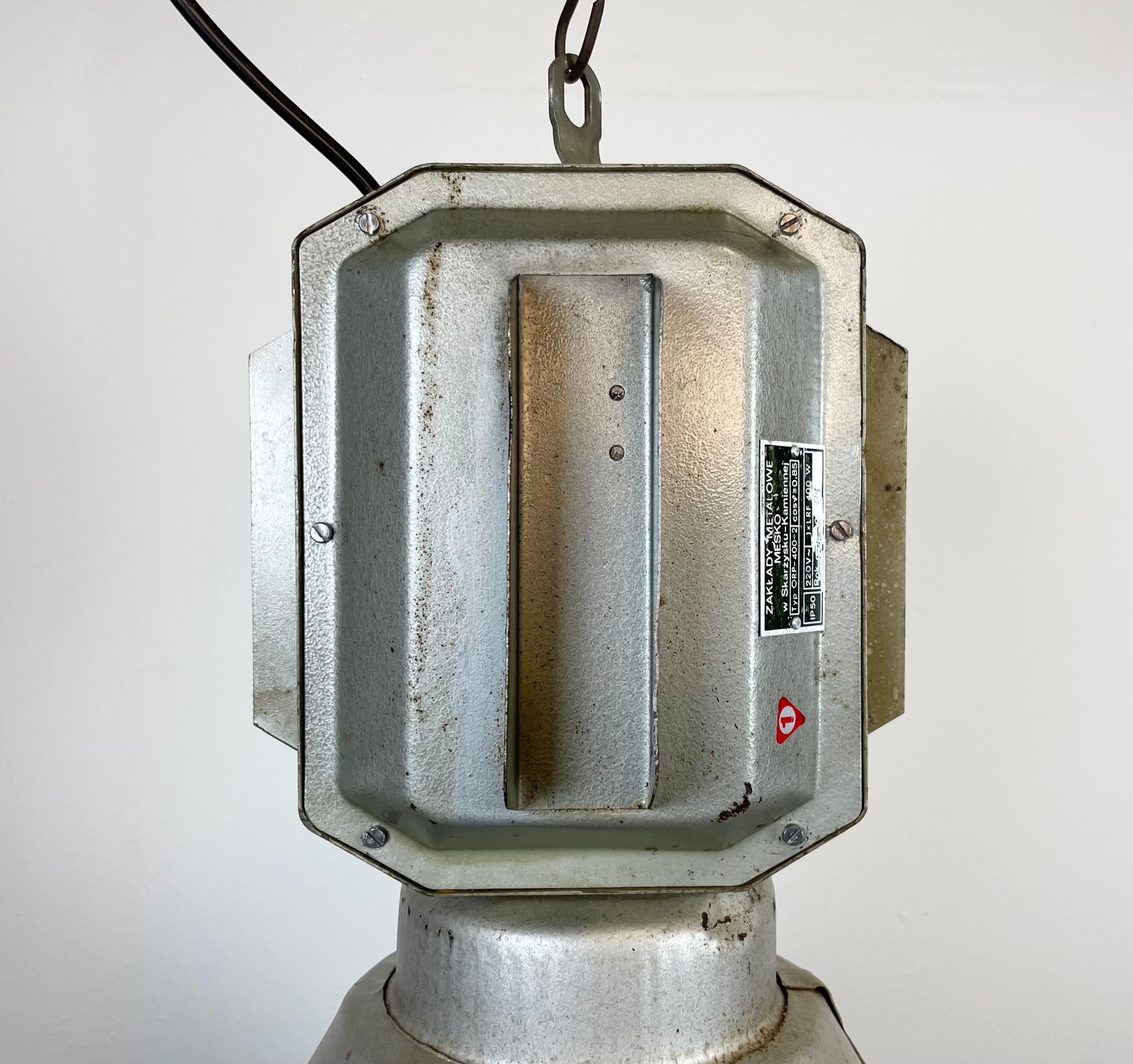 Impressive 'bomb' hanging lamp manufactured by MESKO in Skarzysko-Kamienna in Poland during the 1990s. It features a hammerpaint iron body and an iron grid. New porcelain socket requires E 27/ E26 light bulbs. New wire. The weight of the lamp is 5