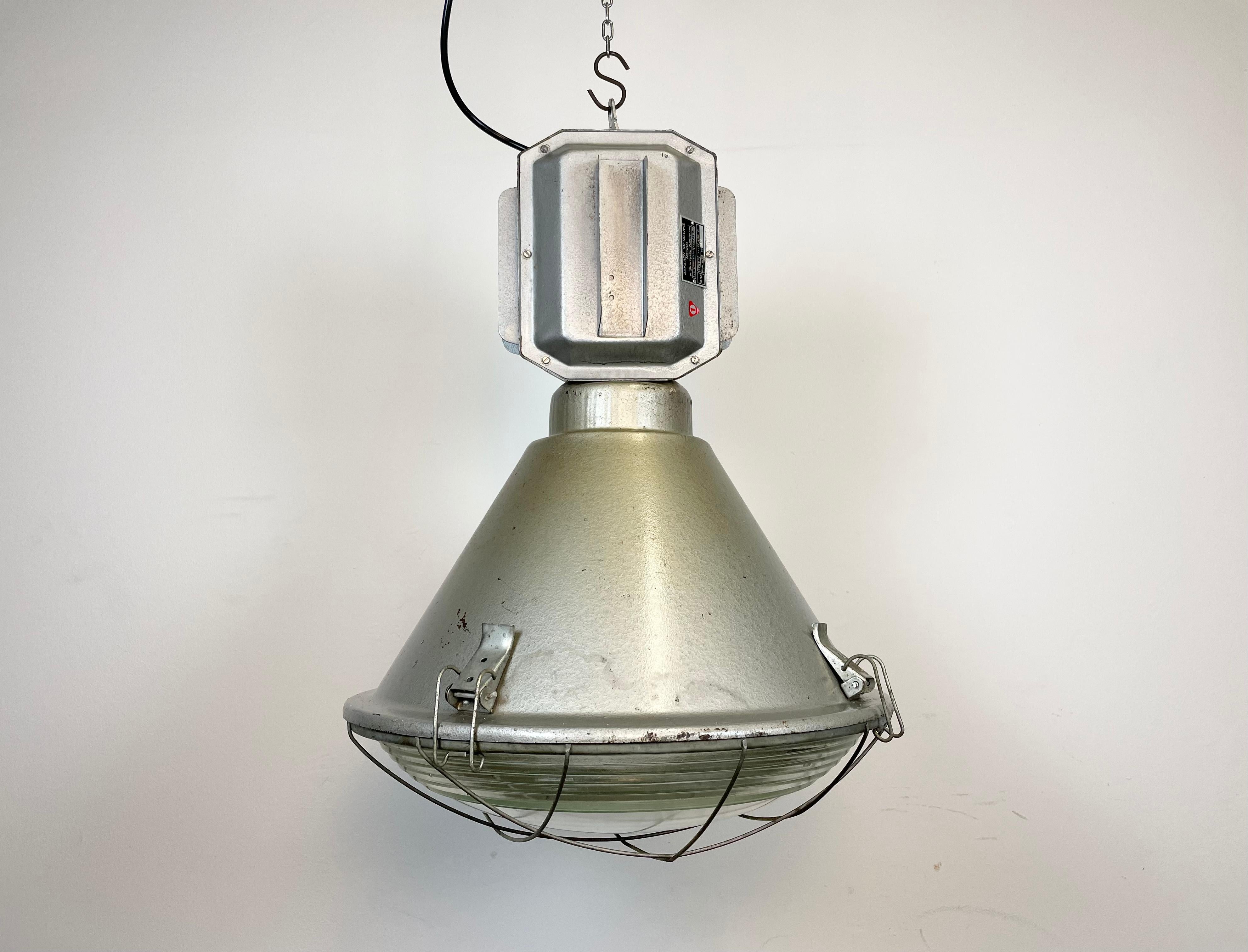 Impressive 'bomb' hanging lamp manufactured in 1990s by MESKO in Skarzysko-Kamienna in Poland. It features a hammerpaint iron body, a clear glass cover and an iron grid. New porcelain socket requires E 27 light bulbs. New wire. The weight of the