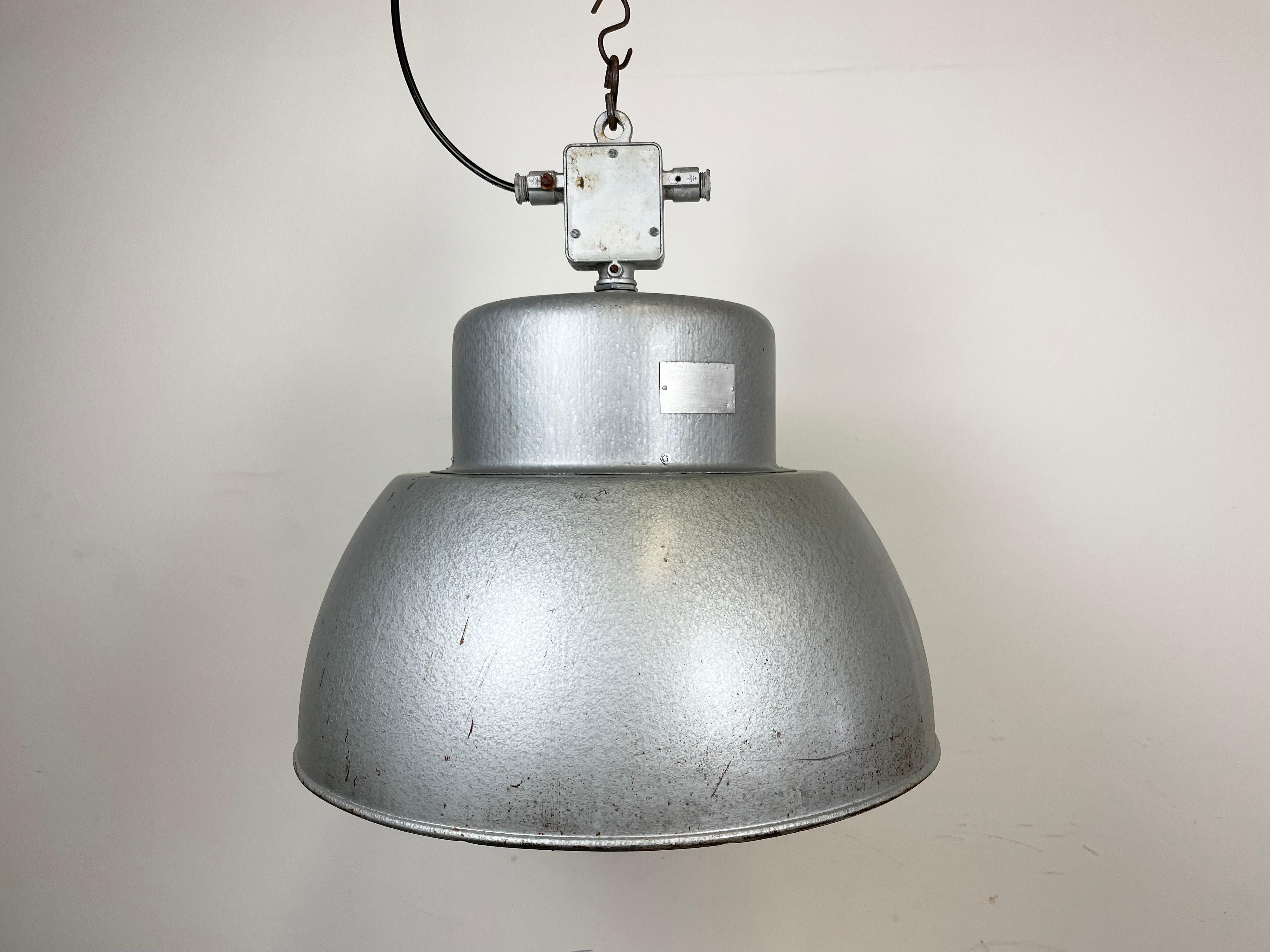 Vintage industrial hanging lamp manufactured in 1970s by MESKO in Skarzysko-Kamienna in Poland. It features a hammerpaint iron body and a cast aluminium top. The porcelain socket requires E 27/E26 light bulbs. New wire. The weight of the lamp is 5