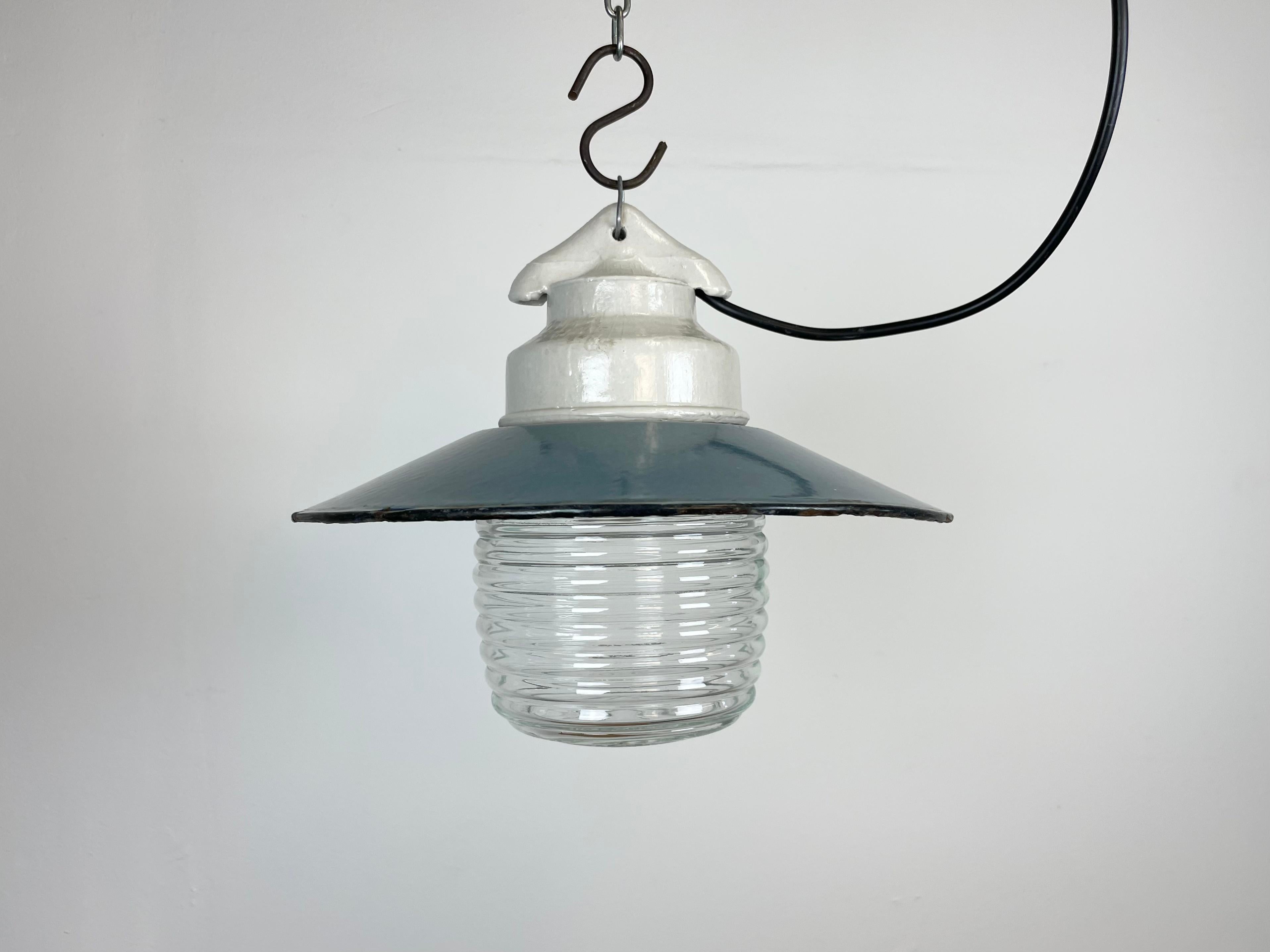 Vintage industrial light made in former Soviet Union during the 1970s.It features white porcelain top, a blue enamel shade with white enamel interior and ribbed clear glass cover. The socket requires E27/ E26  light bulbs. New wire. The weight of