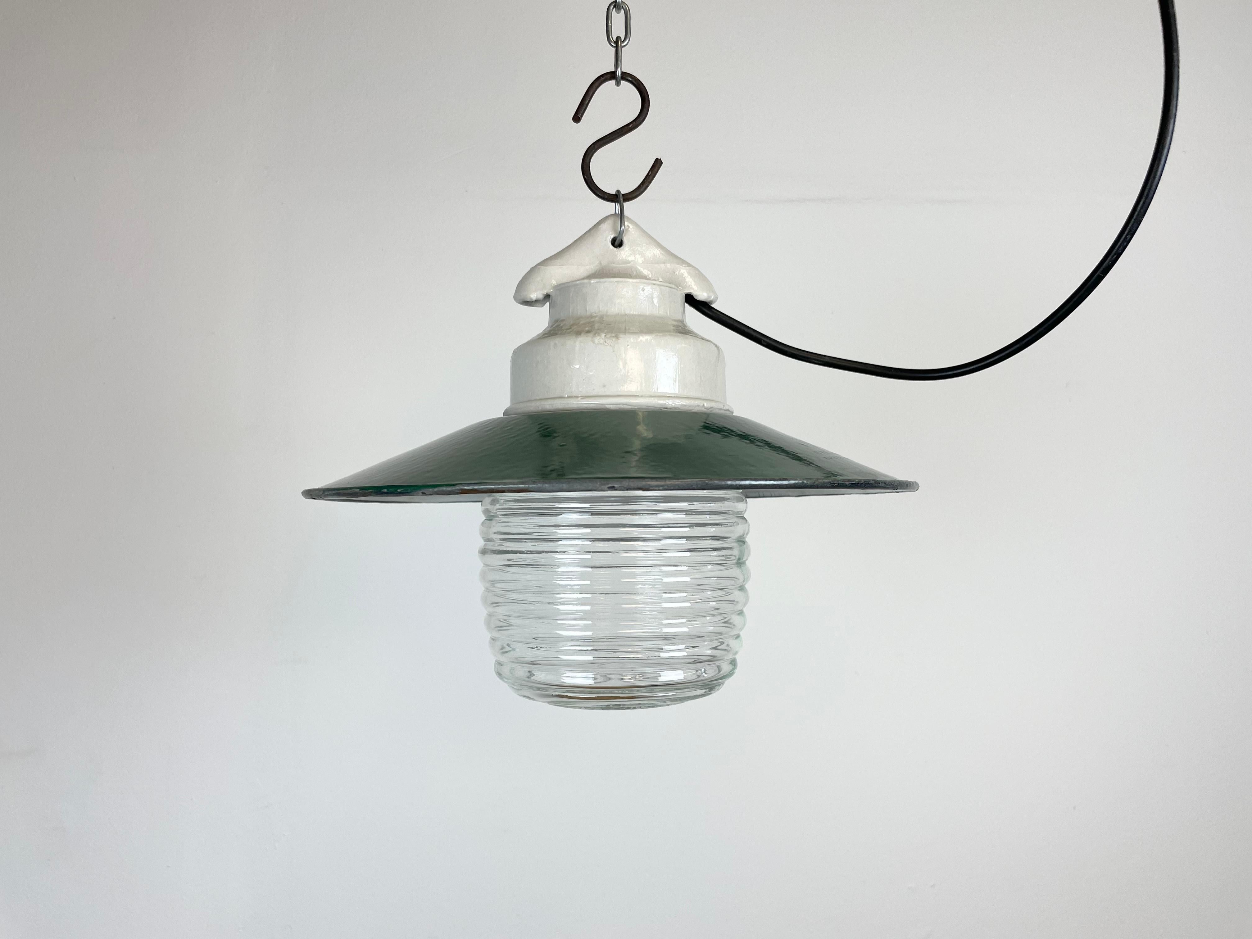 Vintage industrial light made in former Soviet Union during the 1970s.It features white porcelain top, a green enamel shade with white enamel interior and ribbed clear glass cover. The socket requires E27/ E26 light bulbs. New wire. The weight of