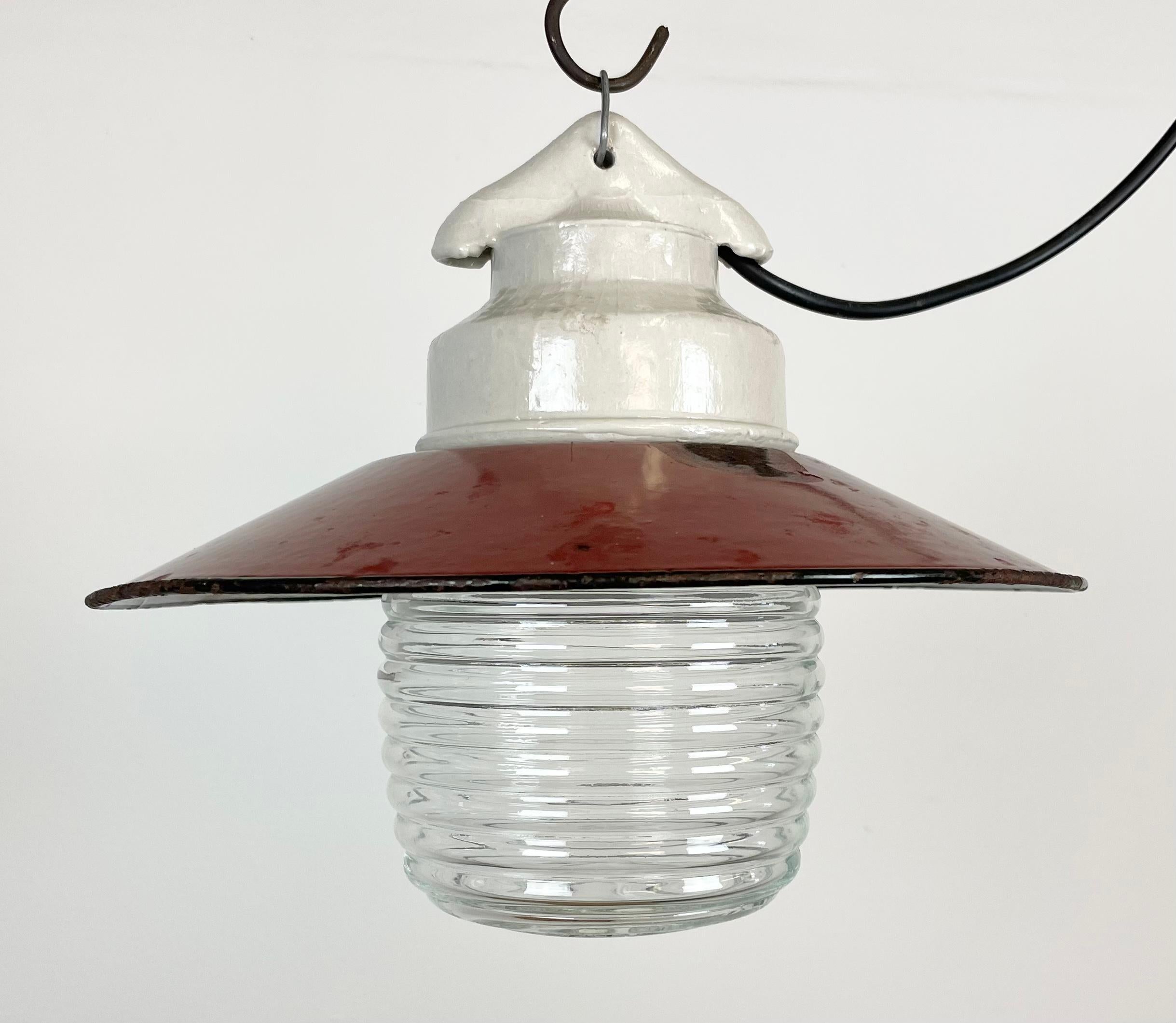 Vintage industrial light made in former Soviet Union during the 1970s.It features white porcelain top, red enamel shade with white enamel interior and ribbed clear glass cover. The socket requires E27/ E26 light bulbs. New wire. The weight of the