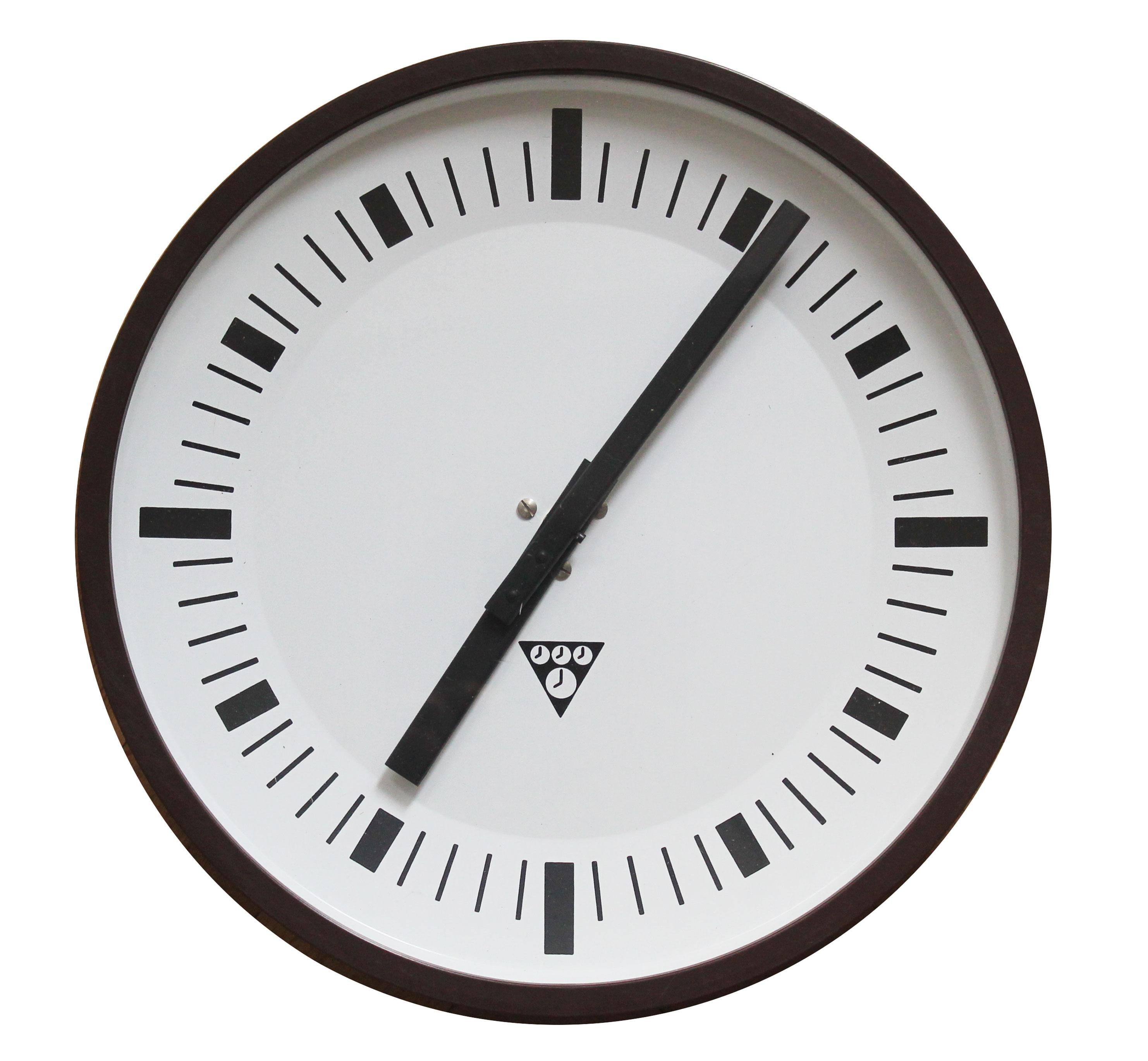 This is an unique Pragotron PK-27 wall clock with distinctive brown outer frame that was produced in small quantities. Its an original industrial wall clock from the 1960s Czechoslovakia.

Pragotron Company (with their trademark triangular logo of