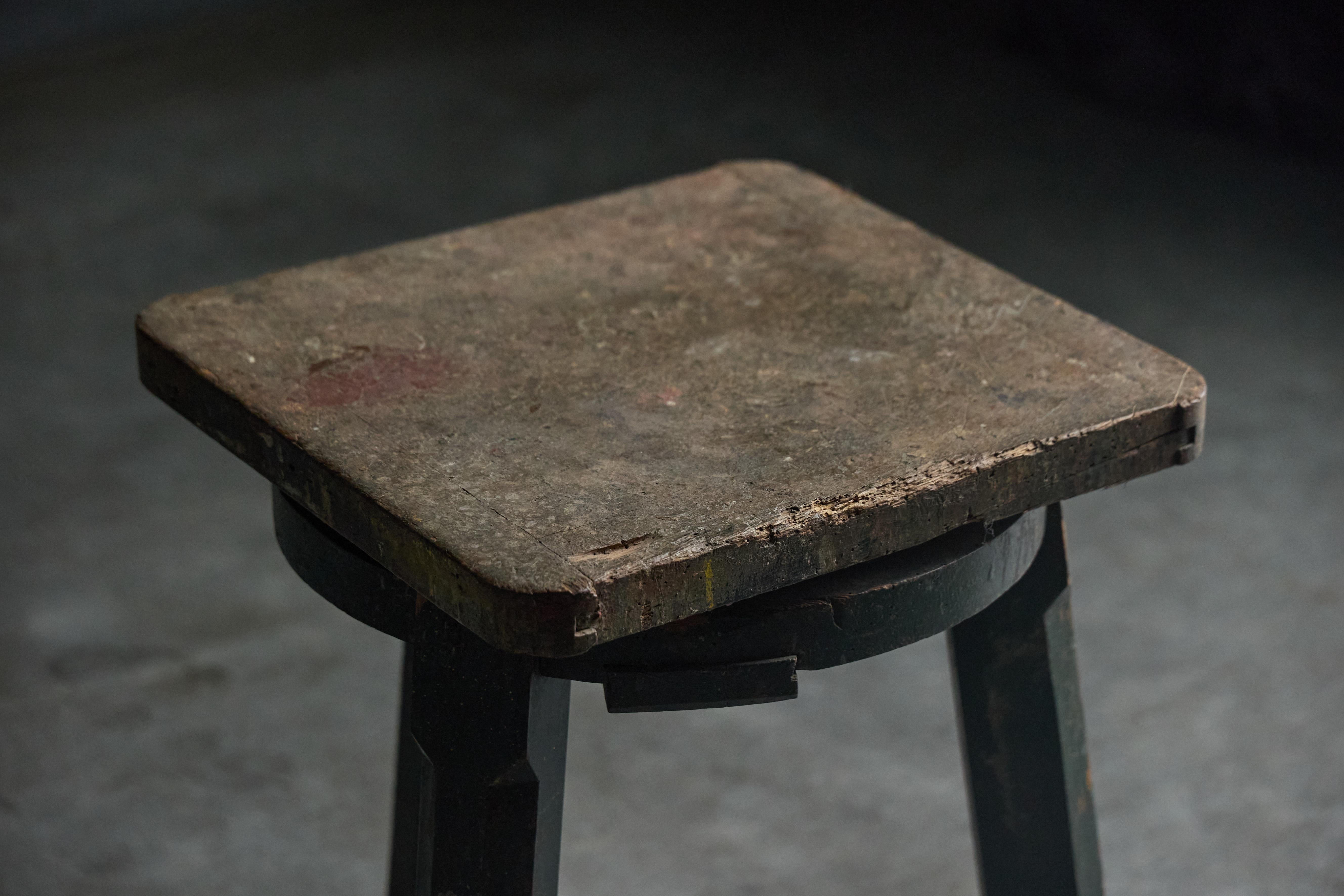 Ce tabouret d'artisan industriel du XIXe siècle incarne une fonctionnalité robuste et un savoir-faire intemporel. Utilisé à l'origine par des artisans qualifiés, sa construction robuste et sa finition verte altérée témoignent d'années d'utilisation