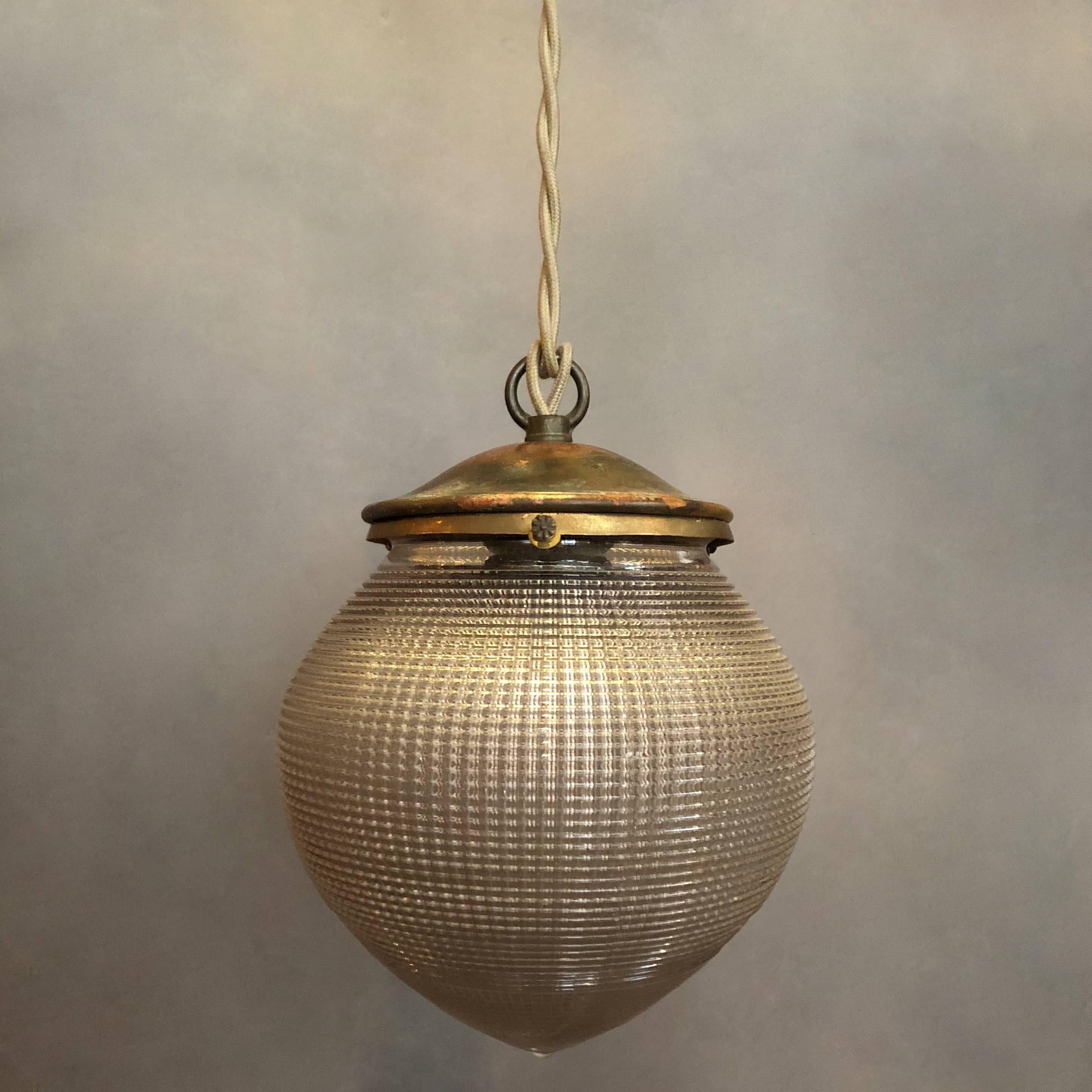 Industrial pendant light features an acorn shaped, prismatic Holophane glass shade with brass fitter is newly wired with 48in. of braided cloth cord to accept a 150 watt bulb.
