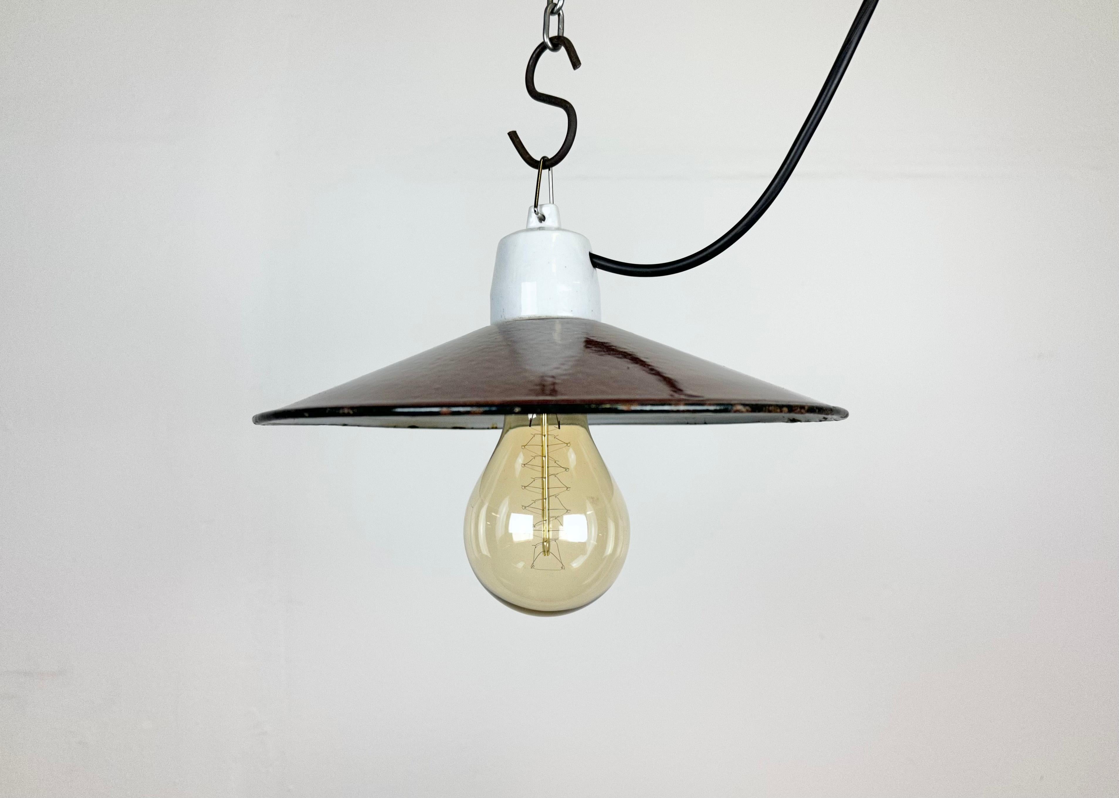 Vintage industrial enamel pendant lamp made in Poland during the 1970s. It features a red enamel shade with white enamel interior and porcelain top. The socket requires E 27/ E 26 light bulbs. The weight of the lamp is 0,5 kg. New wire.