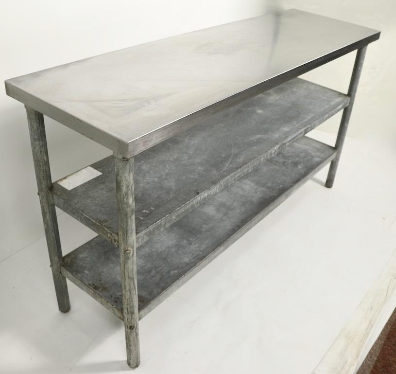 Very nice vintage industrial, commercial, restaurant grade work table of rectangular form. This example has a stainless top over two galvanized shelves, on tubular legs. Obviously sturdy and solid, unlike many we find, this one is a manageable, not