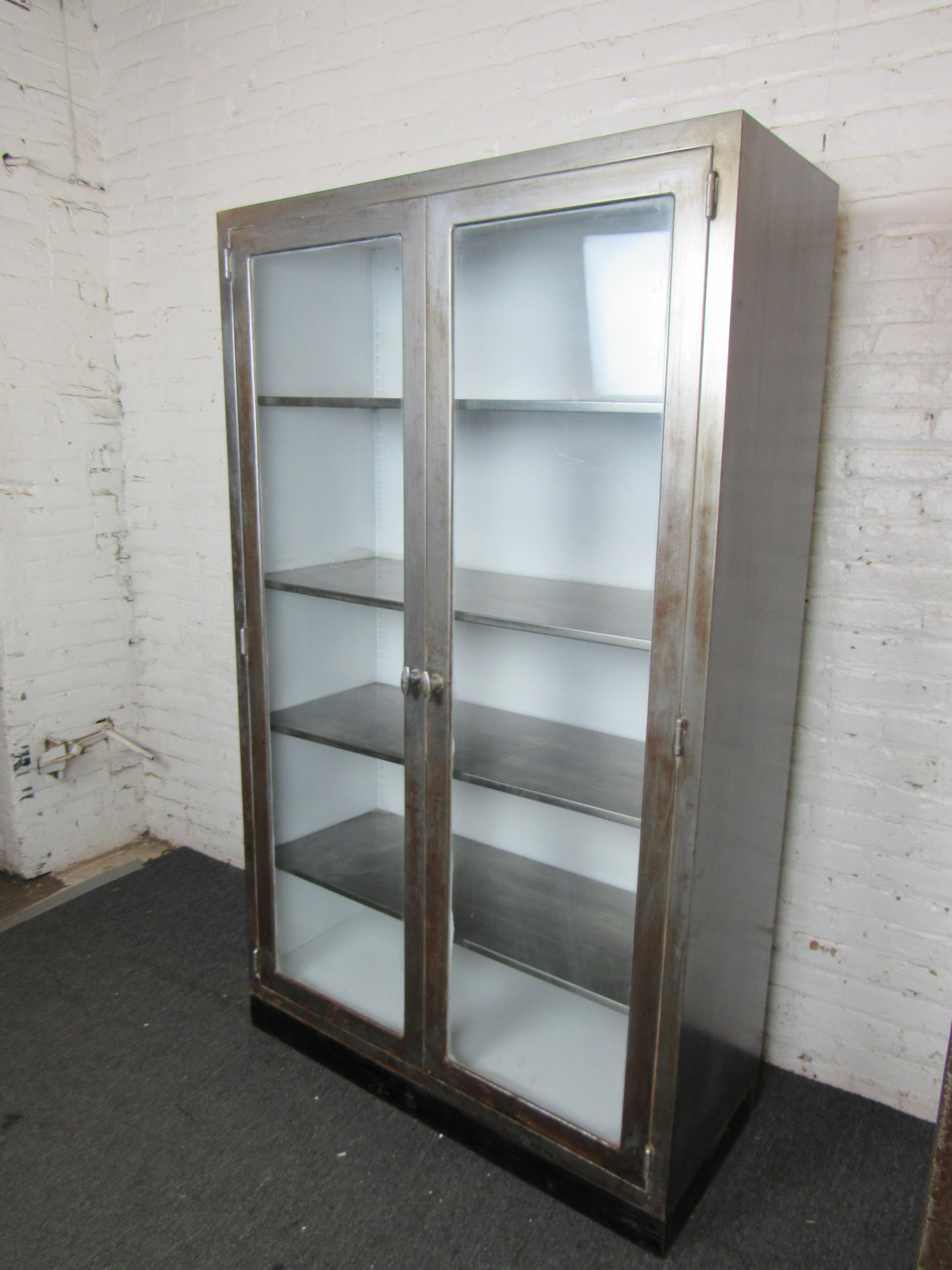 Striking industrial metal factory cabinet that has been restored with a bare metal design. Can be used as a display cabinet or for storage now. Has adjustable platforms. Glass doors with working handles. 
(Please confirm item location - NY or NJ -