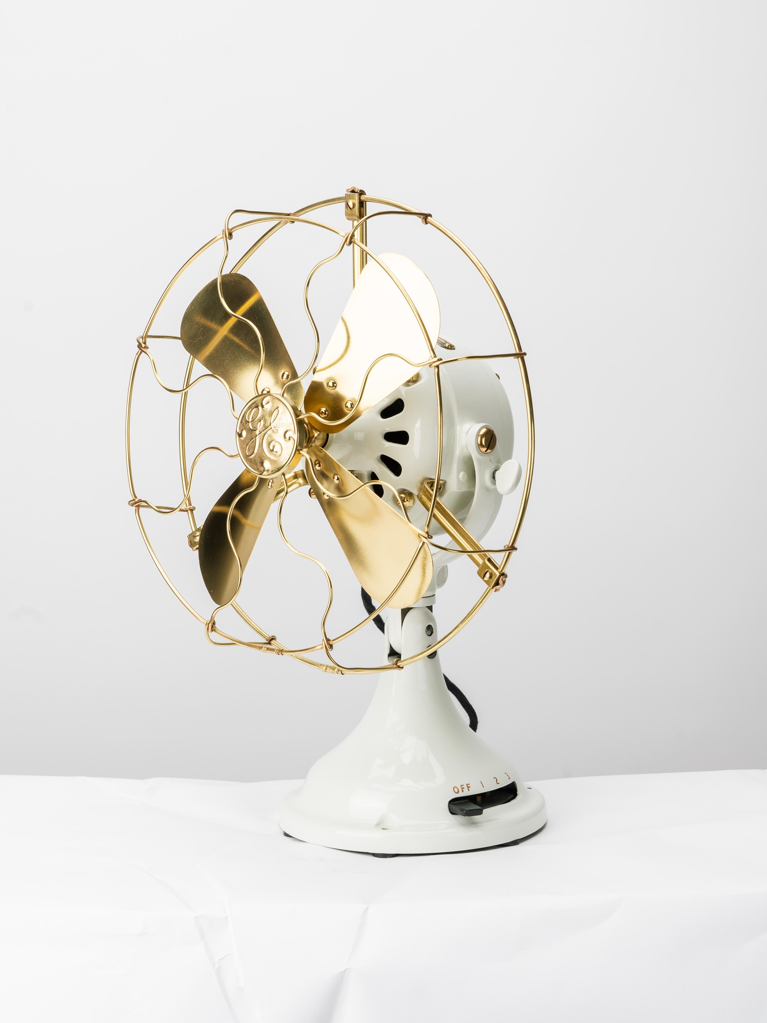 This turn of the century General Electric desk fan has been fully restored both mechanically and cosmetically. Refinished and painted in antiqued white powder coat, the finish is visually and aesthetically closer to white porcelain than paint. Brass