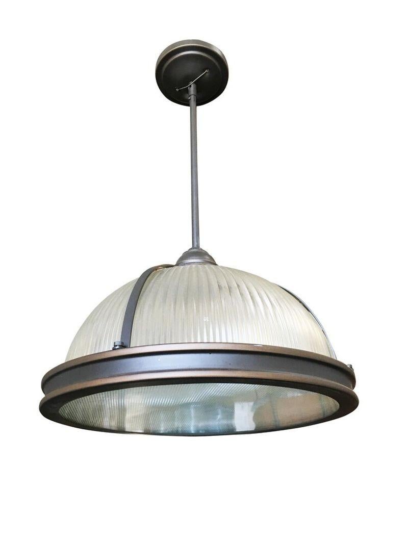 Steel industrial style ribbed glass pendant lamp Holophane finished in a dark finish Pair

A holophane glass ceiling fixture is a type of lighting fixture that features a glass shade with a prismatic design that refracts light to create a soft,