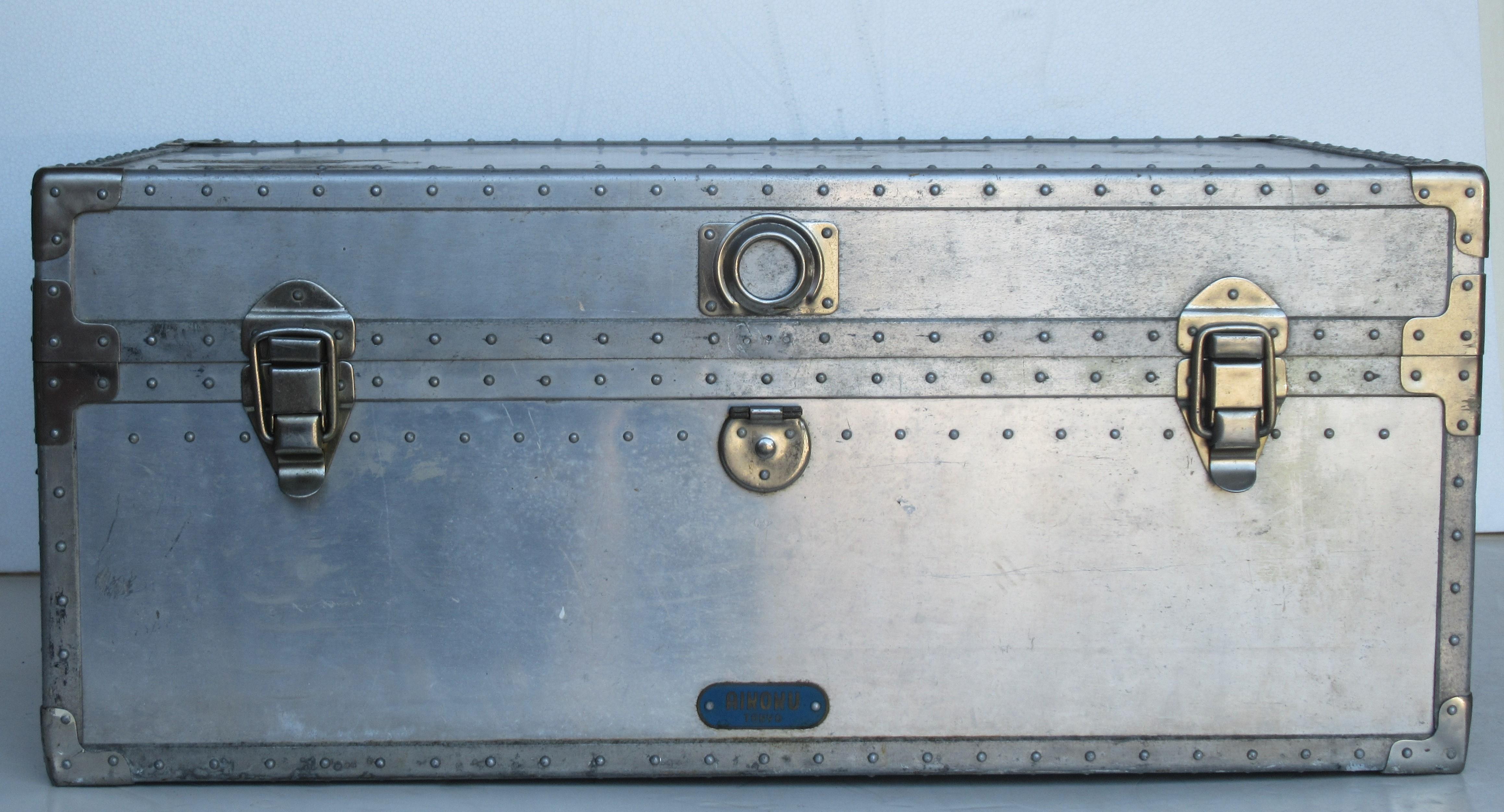 Industrial riveted aluminum trunk with leather handles in all original nicely aged color patina. Raised blue metal plate at front center bottom says Aikoku - Tokyo - circa 1940s. See all pictures.