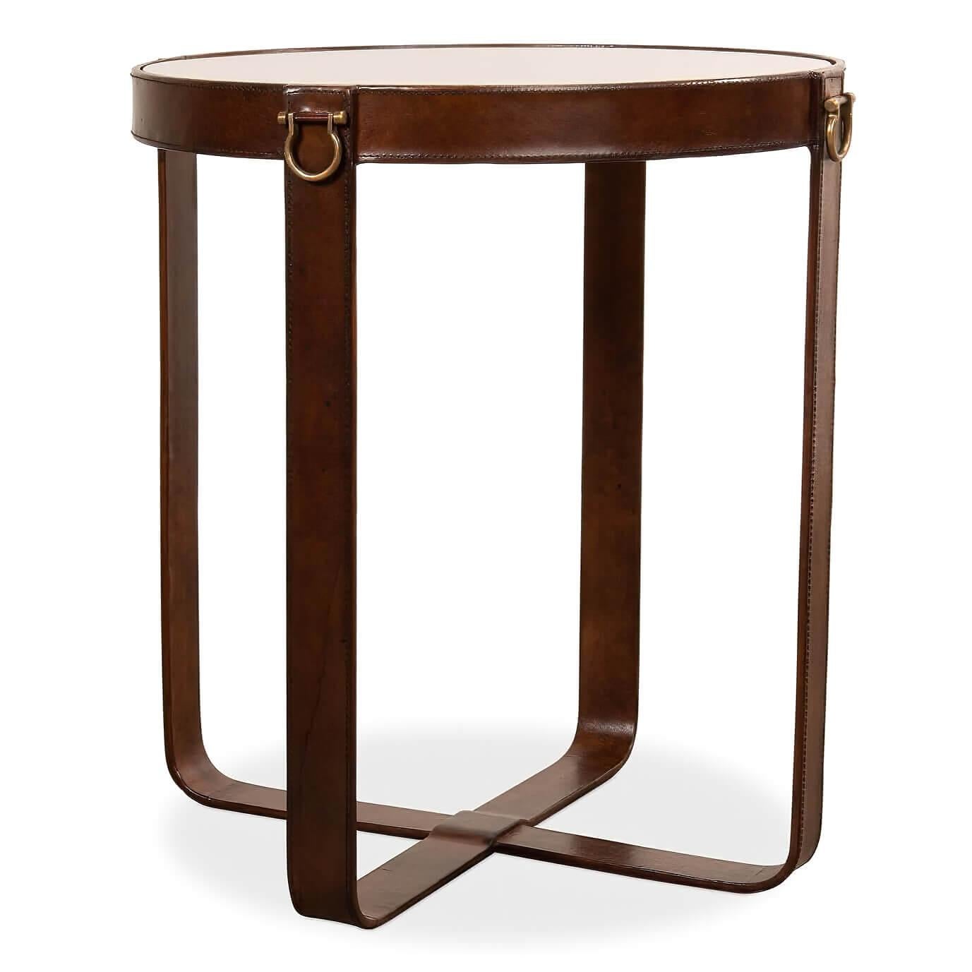 An Industrial round leather and glass end table. This table has an equestrian-inspired design. The top is glass and is supported by four legs wrapped in leather with stitching and brass accents. 

Dimensions: 20