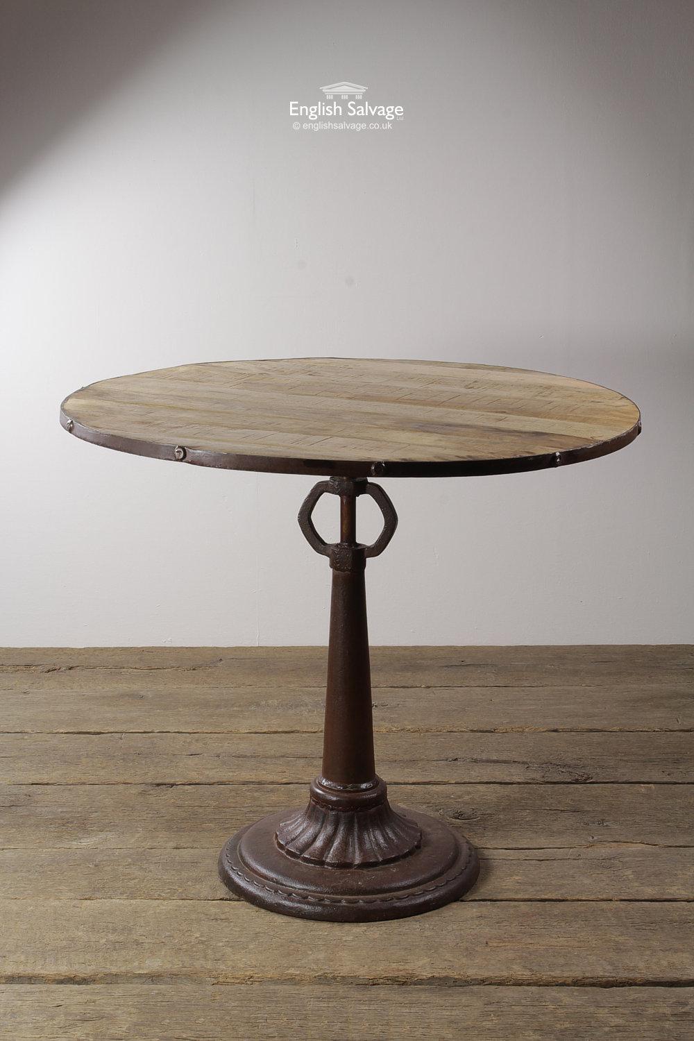 New table with a round teak plank top and a flared or skirted metal base. This vintage industrial style piece would be great for a cafe or home kitchen. The table assembles in two pieces, the wood top screws on to the base.

Good, solid condition.