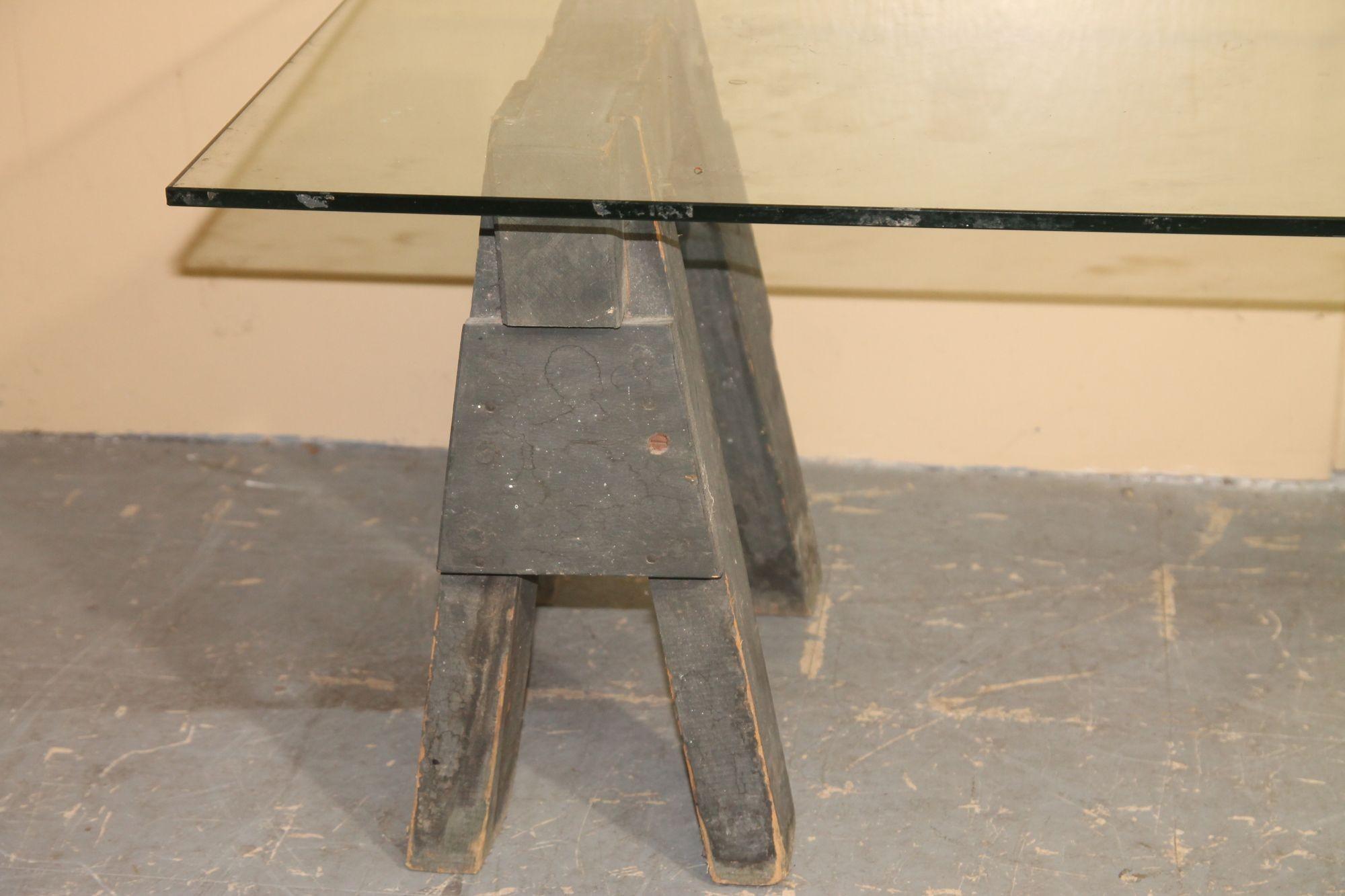 Great pair of small wood industrial sawhorses and glass top coffee table. This piece will look great in any decor.