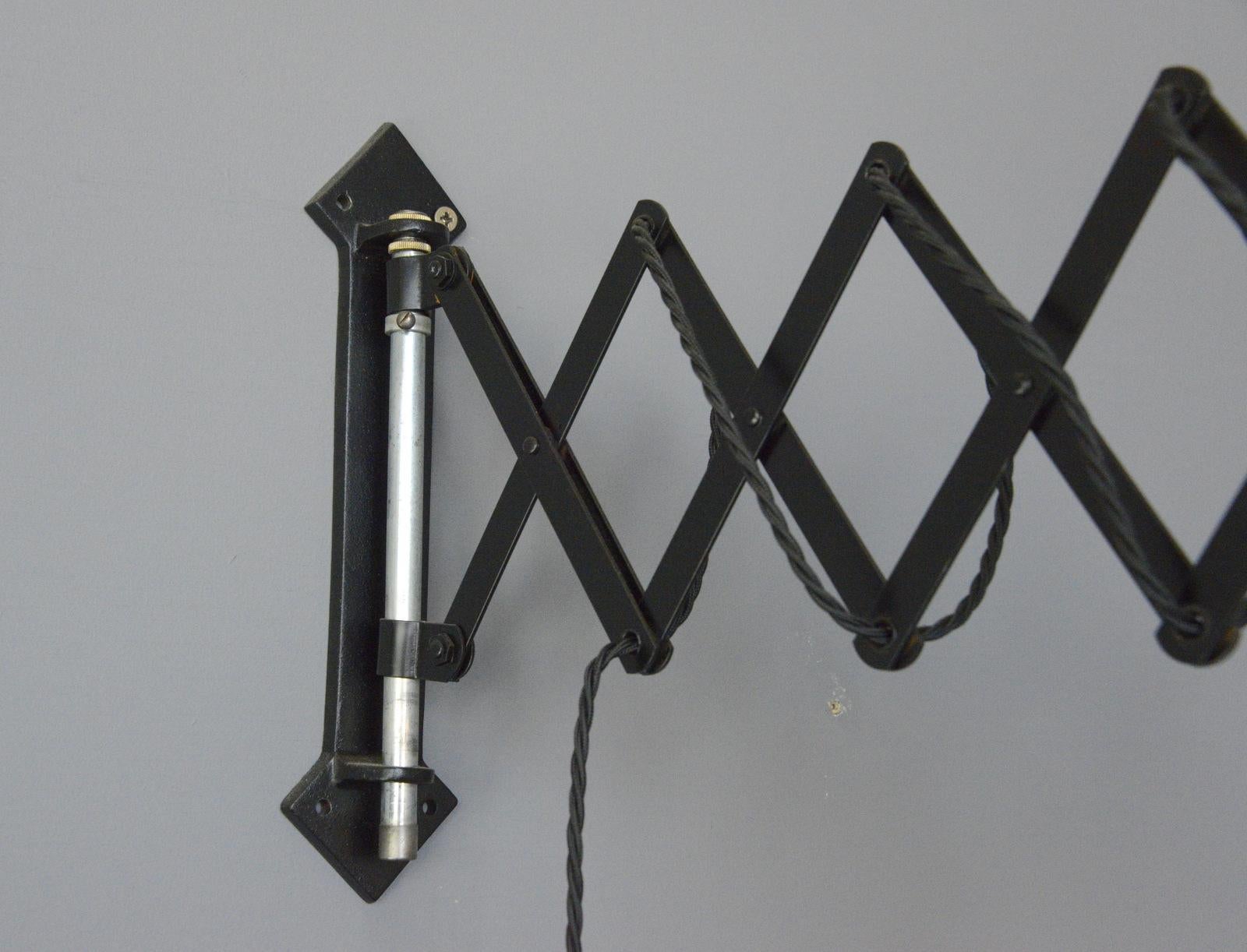 Industrial scissor lamp circa 1930s

- Extendable scissor mechanism 
- Cast iron wall bracket with arrow head design
- Steel shade
- On/Off toggle switch on the shade
- Takes E27 fitting bulbs
- German ~ 1930s
- Measures: 29cm tall x 16cm