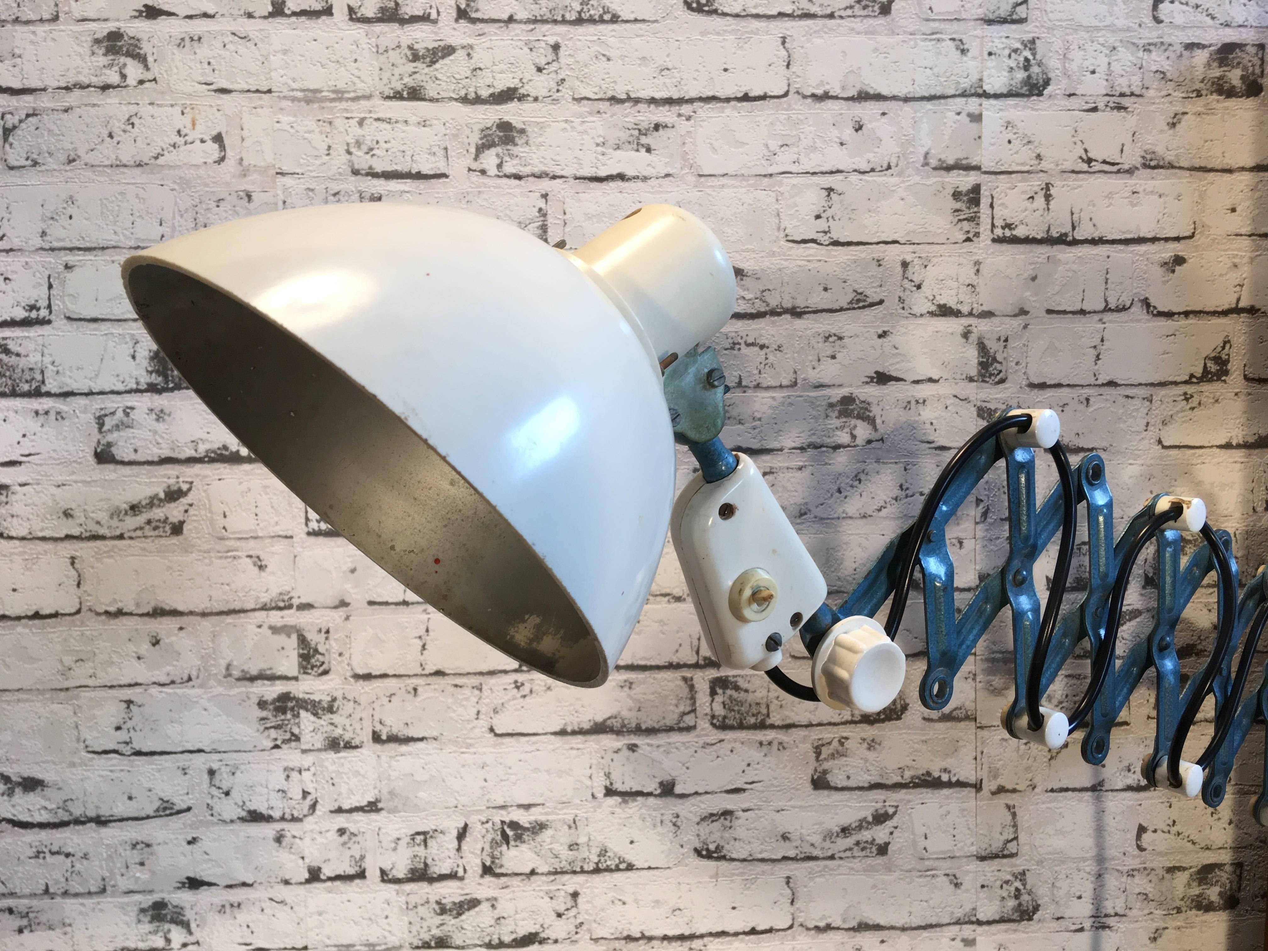 This vintage industrial scissor lamp was produced by Reif Dresden in former East Germany in the 1950s. Lamp has white bakelite shade. Blue iron scissor arm is extendable and can be turned sideways. Fully functional. Very nice vintage