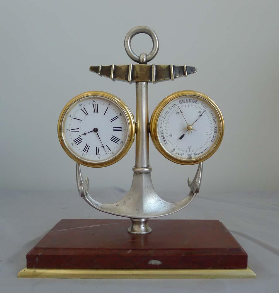 A very rare antique Industrial Series Marine deskset or compendium of clock, barometer and thermometer within an anchor and of small size.. Set upon an ormolu and rouge marble rectangular base the working parts are set within a robust silvered