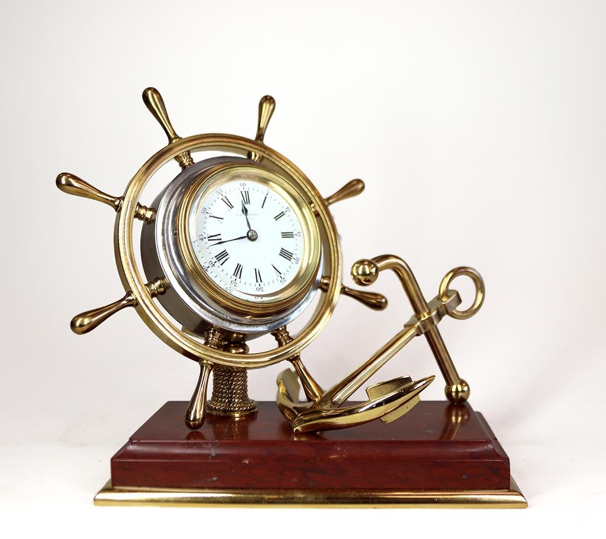 This stylish desk clock made in the last quarter of the 19th century has a french eight day movement with a lever platform escapement. the movement is housed in a drum forming the centre of a ships wheel, the drum and back cap are nickel plated,