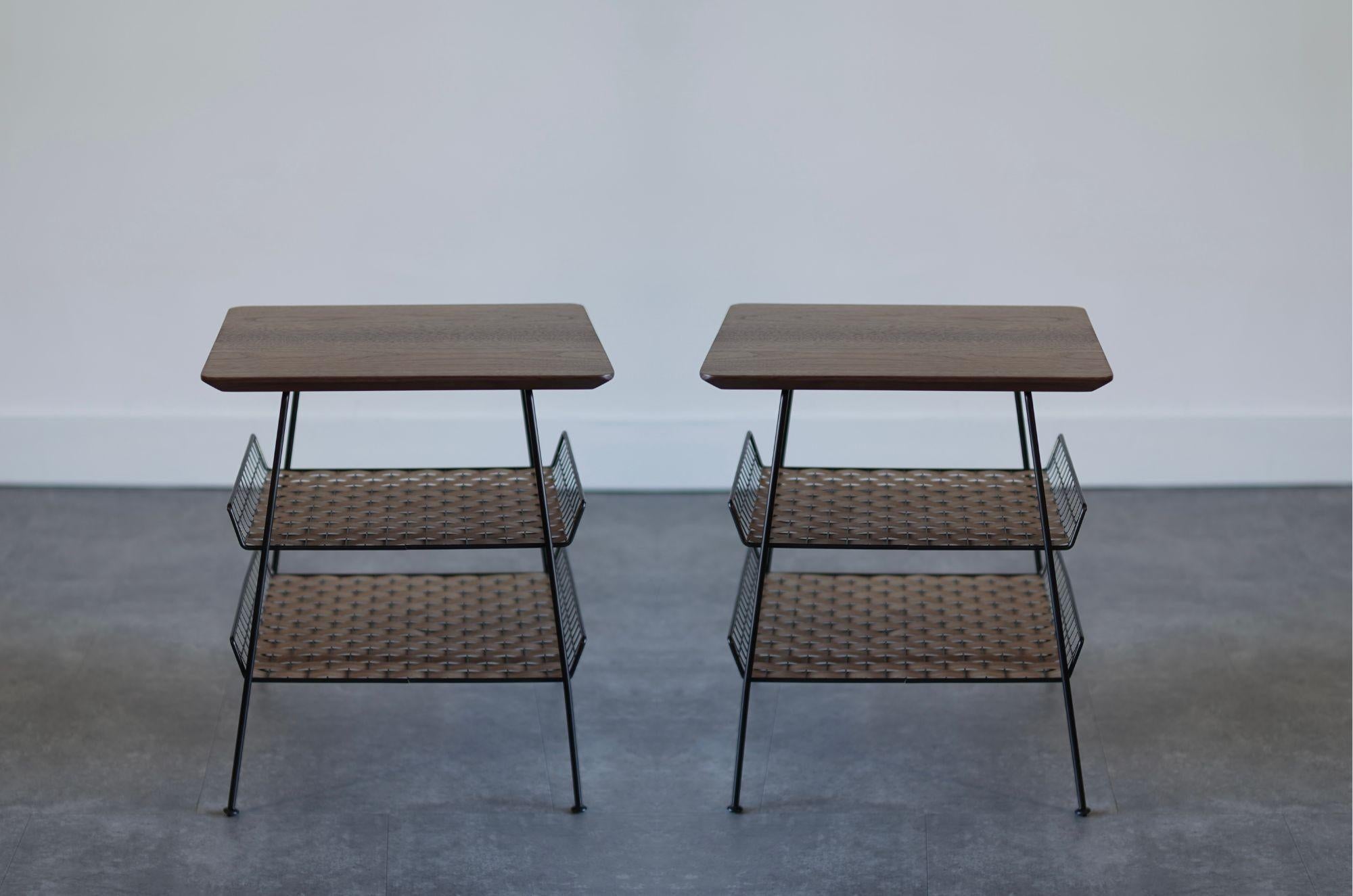 Ein auffälliges Paar industrieller Beistelltische von Tony Paul, circa 1960er Jahre, vollständig restauriert von Stamford Modern. Mit massiven Walnussholzplatten und handgeflochtenen Walnussholzböden zeigen diese Tische Pauls charakteristische