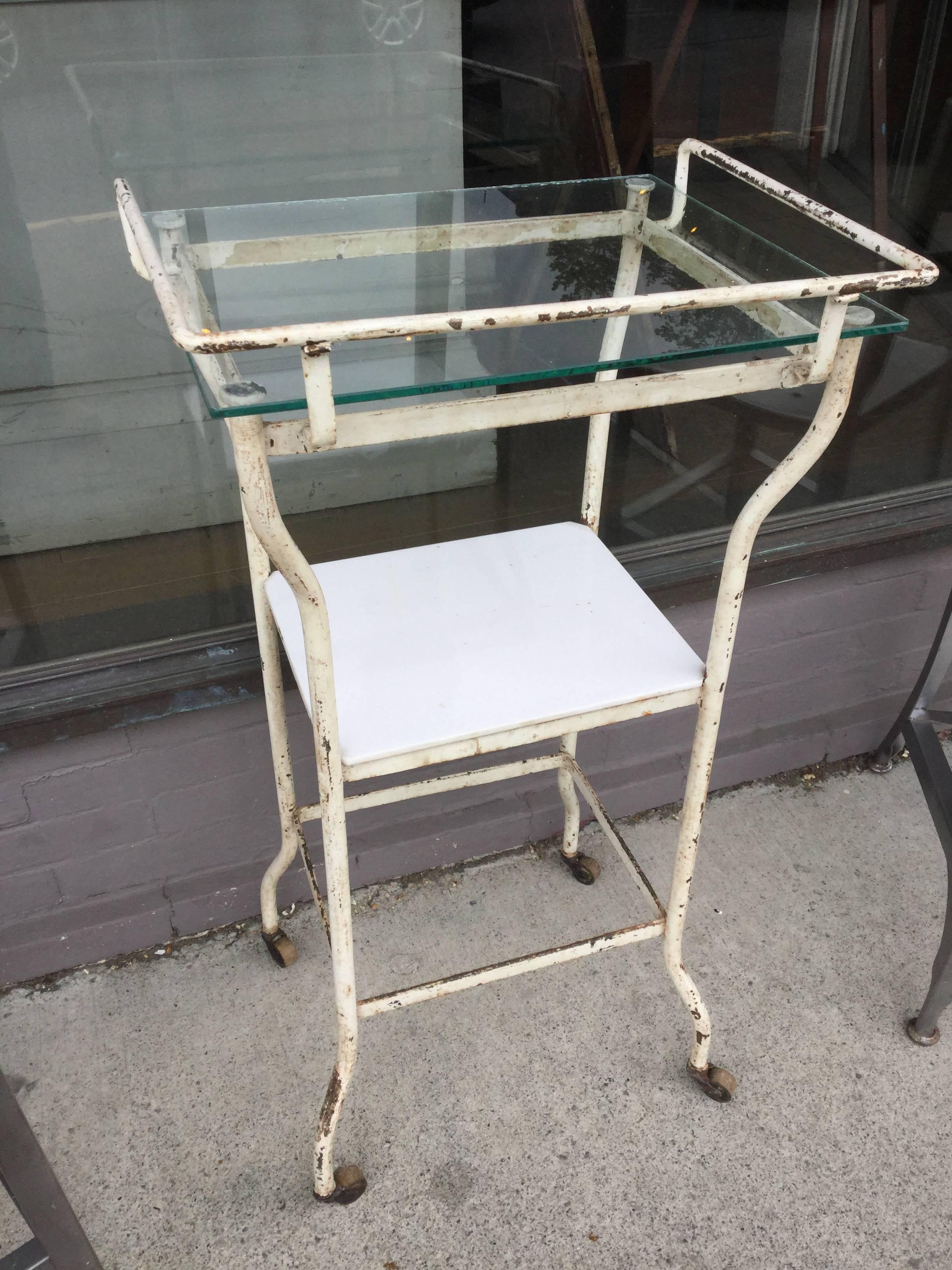 Industrial side table with two shelves. One shelf is milk glass. Originally used in a medical setting.