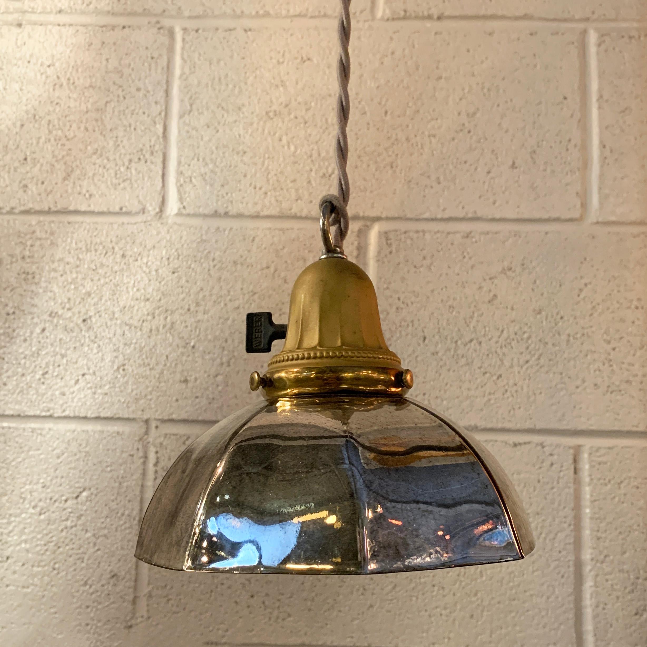 Industrial pendant light with faceted bell shaped, silver mercury glass shade and brass fitter with paddle switch is newly wired with 40 inches of silver braided cloth cord to accept up to a 75 watt bulb.