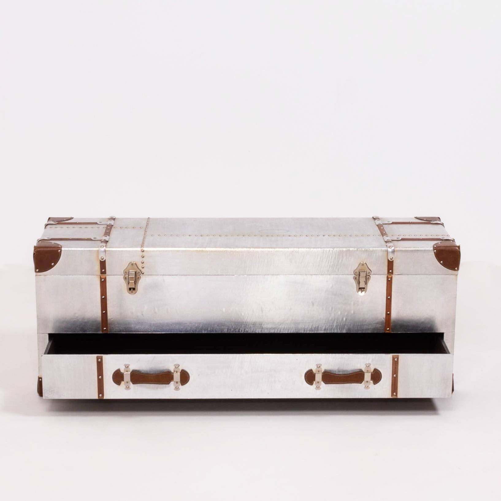 This Industrial style silver storage trunk is constructed from a wood frame and wrapped in aluminium with brass rivet detailing. With leather pulls and details this trunk is sure to make a statement in any home. An easy pull out drawer is great to