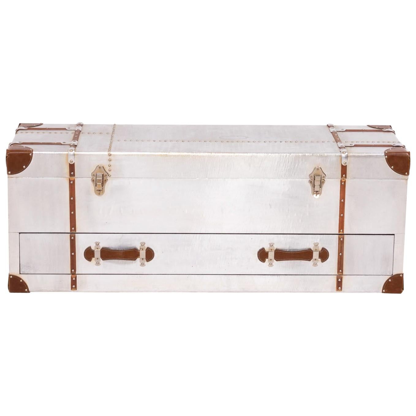 This Industrial style silver storage trunk is constructed from a wood frame and wrapped in aluminium with brass rivet detailing. 
With leather pulls and details this trunk is sure to make a statement in any home. An easy pull out drawer is great to
