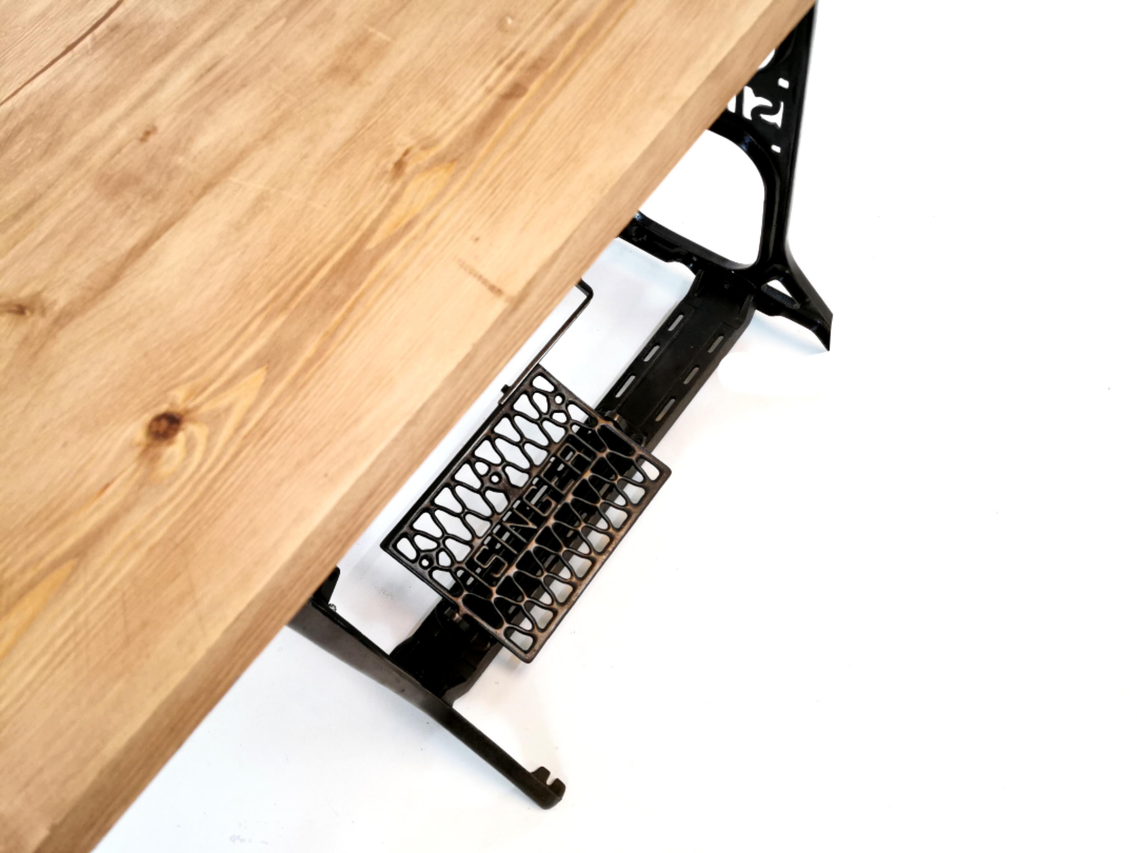 Industrial singer machinists stand fitted with a reclaimed wooden top.

The stand was made at Singers Kilbowie factory in Clydebank Scotland during the early midcentury.

High-quality thick wood top and a solid metal stand.