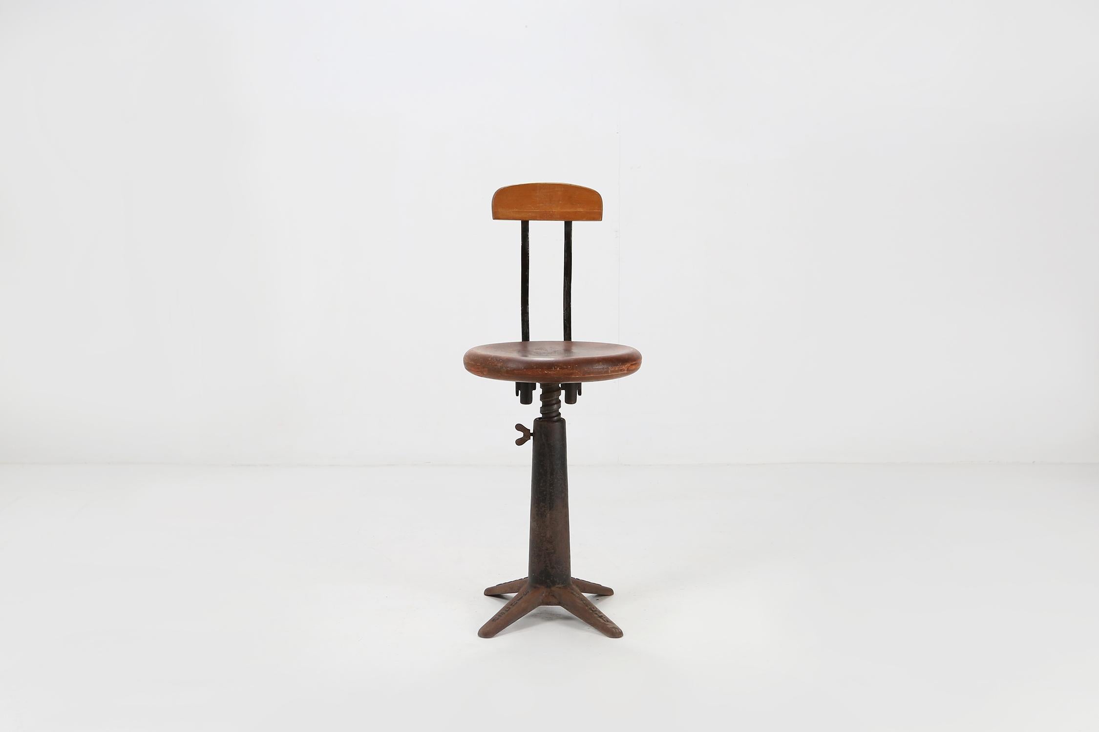 Industrial stool of the Singer Sewing Machine Company.
Made of a cast iron base whit a solid wooden seat that can be adjust in height with a screw.

The company brand in the base gives the stool a unique look.

Seat height: 45-64 cm.