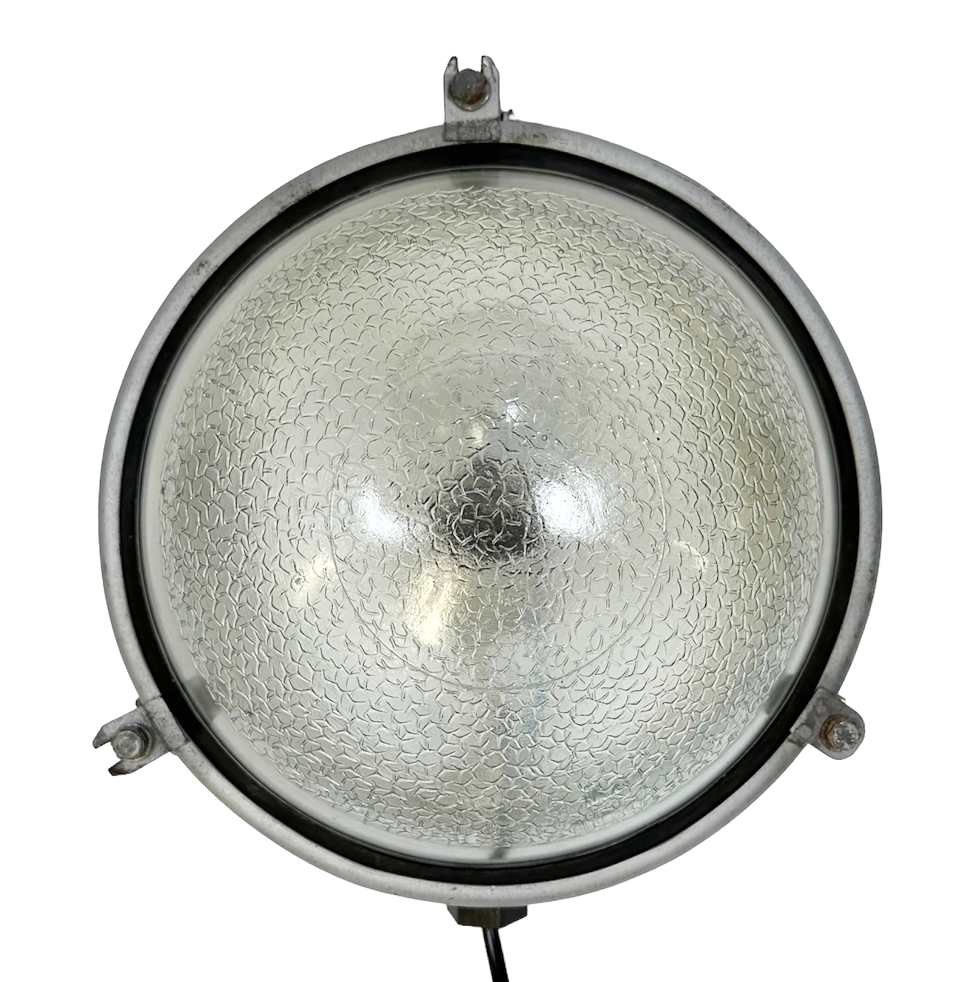 Industrial wall light made in former Soviet Union during the 1970s. It features a grey metal body and a frosted glass cover. The porcelain sockets requires E 27/E 26 light bulbs. New wire. The weight of the lamp is 2kg. The light can be also used as