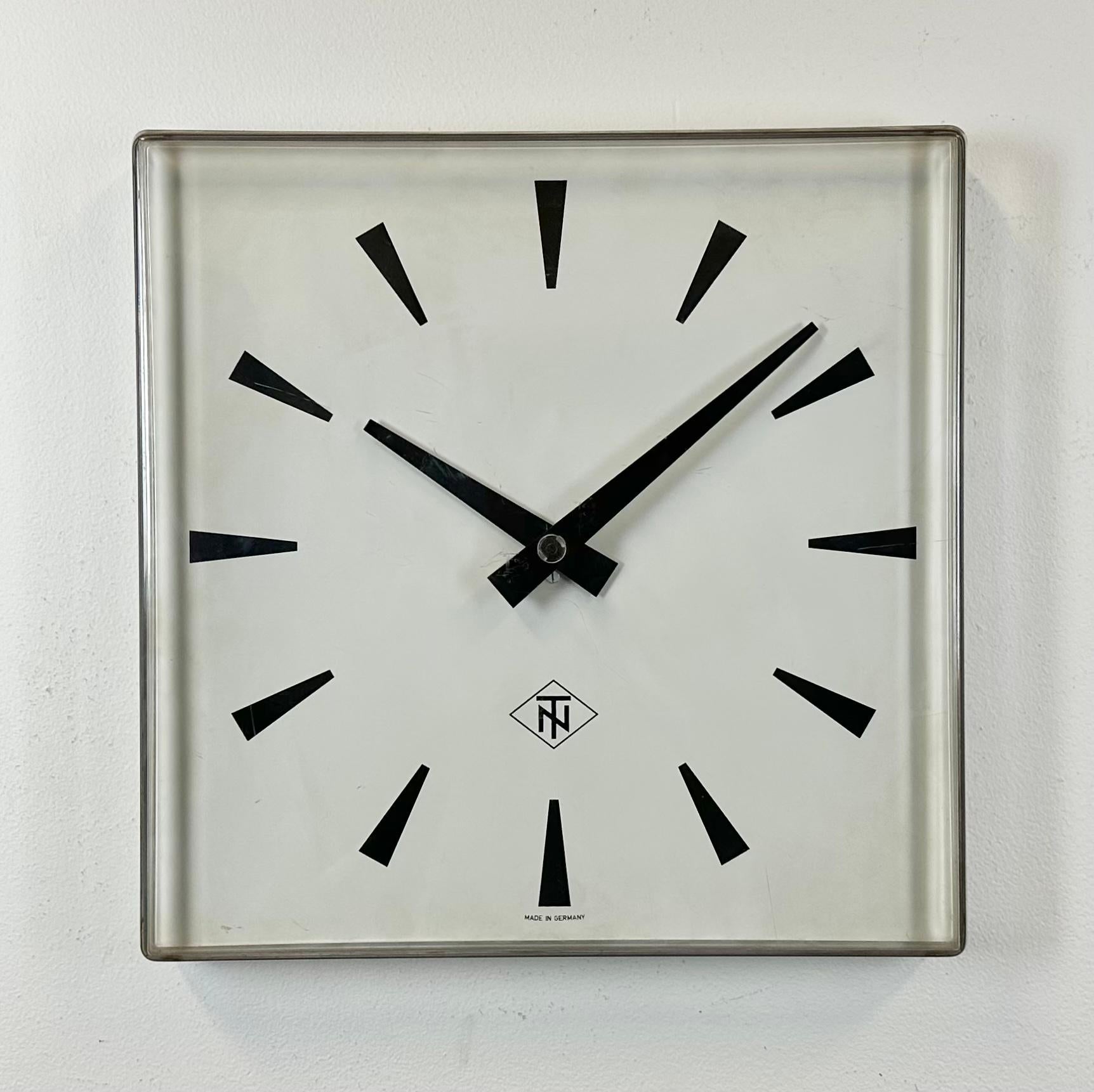 Vintage wall clock produced by TN “Telefonbau und Normalzeit” in Germany during the 1970s. It features a clear convex plexiglass frame, a white metal dial and black aluminium hands. The piece has been converted into a battery-powered clockwork and