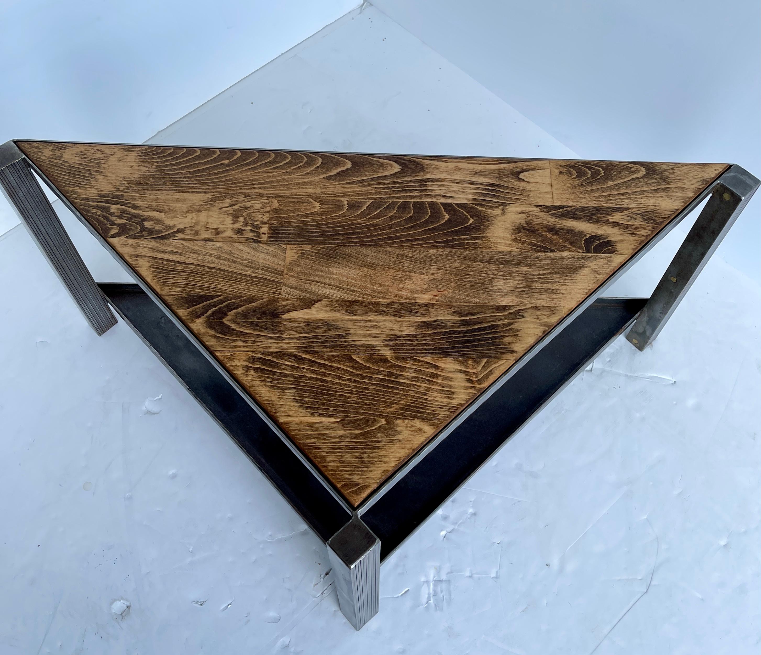 Custom made, one of a kind, stainless steel table with richly stained oak plank inset top and steel lower shelf. This modern low profile table has the best of industrial period with warmth of wood earthiness. The brass pegs on the three legs are a