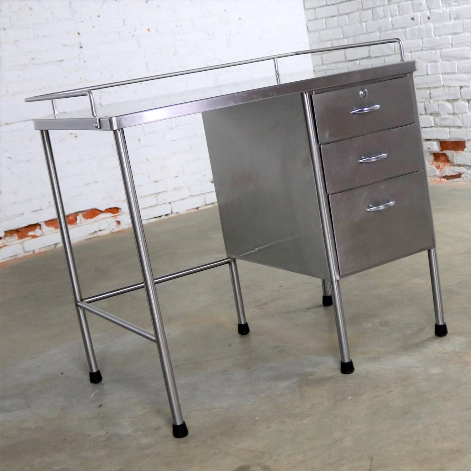 Handsome vintage stainless-steel writing desk. Former industrial or surgical medical desk. In fabulous vintage condition with scratches as you would expect from use, but which gives an overall interesting patina to the stainless steel, circa